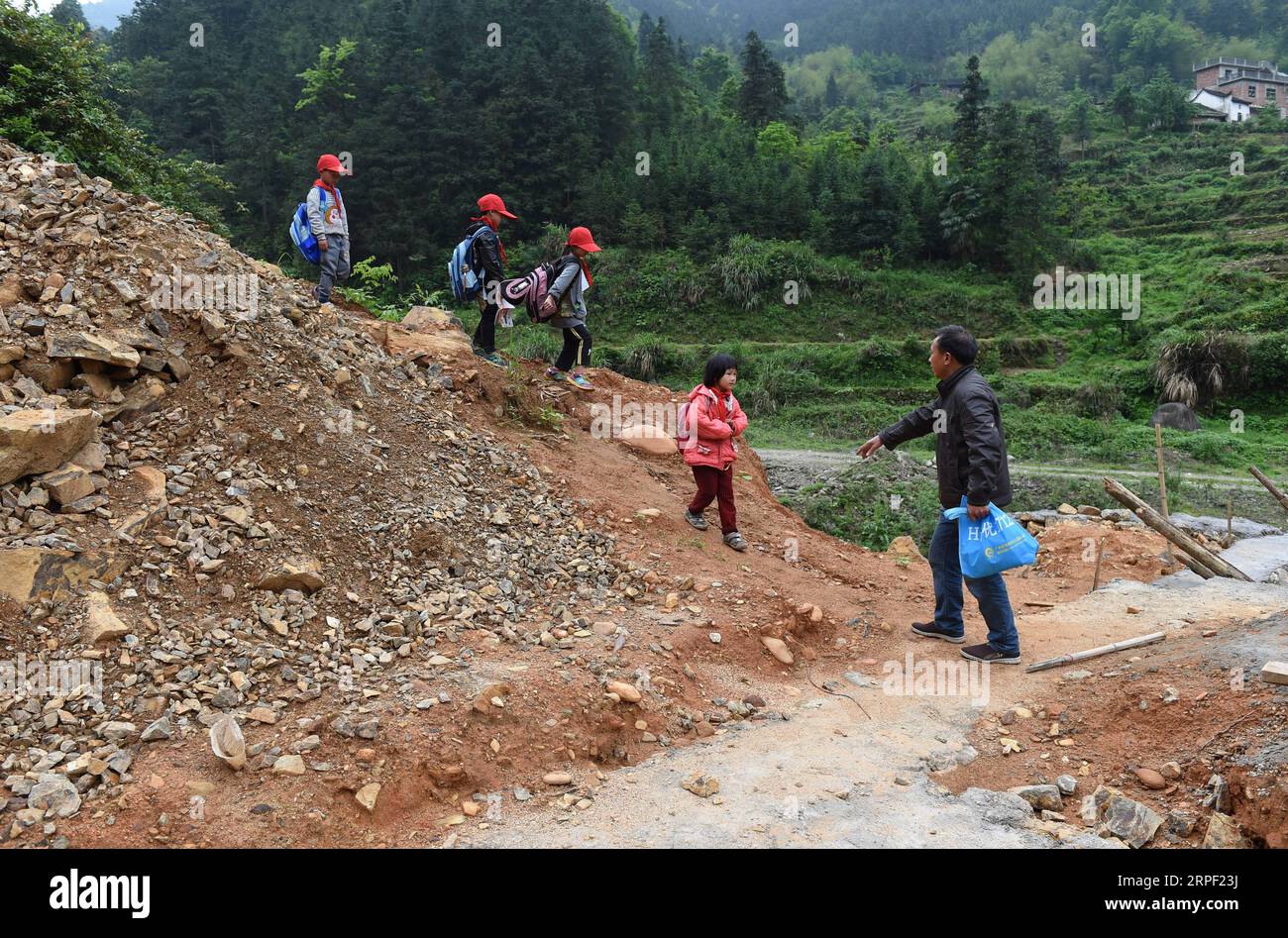 (190910) -- NANNING, 10 septembre 2019 -- l'enseignant lu Jiahong accompagne les élèves pour rentrer chez eux après l'école dans le village de Dayuan, comté de Quanzhou, région autonome de Guangxi Zhuang, sud de la Chine, 28 avril 2016. Depuis 2012, reporter a rendu visite à 250 enseignants dans des zones montagneuses reculées du Guangxi et a enregistré leur vie. Les enseignants y remplissent toujours plusieurs rôles, tels que concierge et cuisinier. Il y a environ 16,74 millions d'enseignants en Chine, une hausse de 79 pour cent par rapport au chiffre de 1985 lorsque la Chine a désigné le 10 septembre comme Journée des enseignants, a déclaré le ministère de l'éducation. Un total de 510 000 nouveaux diplômés ont Bee Banque D'Images