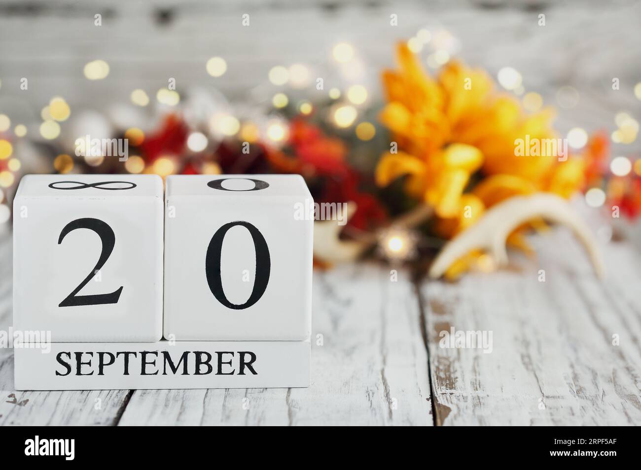 Blocs de calendrier en bois blanc avec la date du 20 septembre et décorations d'automne sur une table en bois. Mise au point sélective avec arrière-plan flou. Banque D'Images