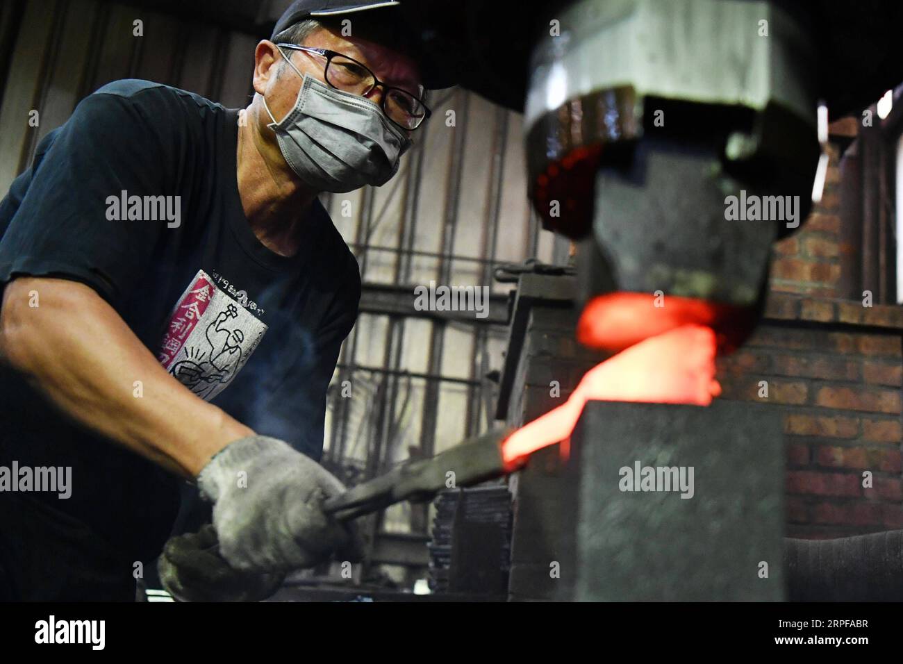 (190918) -- KINMEN, 18 septembre 2019 -- Un artisan forge un couteau en acier Kinmen dans un atelier du sud-est de la Chine, à Kinmen, le 18 septembre 2019. Le couteau en acier forgé avec des matières premières de coquilles jetées est un produit célèbre de Kinmen.) CHINA-KINMEN-CRASTRATISON-COUTEAU EN ACIER (CN) CHENXBIN PUBLICATIONXNOTXINXCHN Banque D'Images