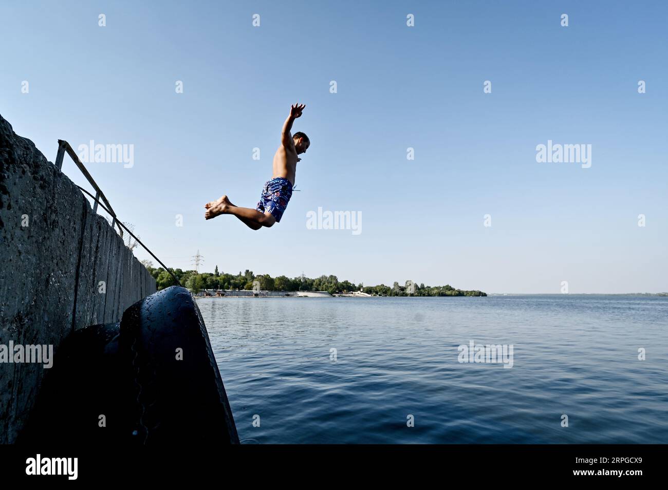 Non exclusive : ZAPORIZHZHIA, UKRAINE - 31 AOÛT 2023 - Un homme plonge dans la rivière Dnipro, Zaporizhzhia, dans le sud de l'Ukraine. Banque D'Images