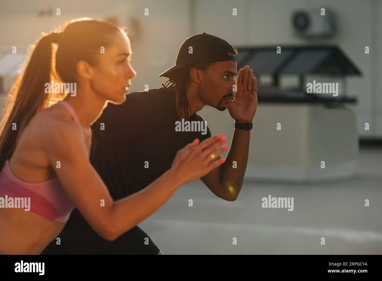 Couple de fitness se préparant à courir au coucher du soleil sur le toit Banque D'Images