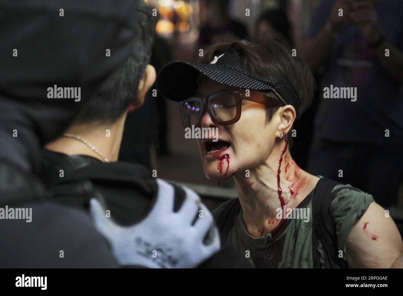 191015 -- HONG KONG, 15 octobre 2019 -- la photo prise le 6 octobre 2019 montre une actrice dont le nom de scène est Céline Ma Tai-lo attaquée par des hommes masqués alors qu'elle prenait des photos de certains émeutiers endommageant des distributeurs automatiques de billets dans une succursale de la Banque de Chine, à Mong Kok, dans le sud de la Chine à Hong Kong. Depuis juin, Hong Kong a souffert de l'escalade de la violence provenant des manifestations contre les amendements proposés à l'ordonnance concernant les transferts de fugitifs. La Perle de l'Orient a été en proie à des troubles alors que des manifestants radicaux, souvent vêtus de noir et masqués, ont incendié les rues, vandalisé les installations publiques, y compris metr Banque D'Images