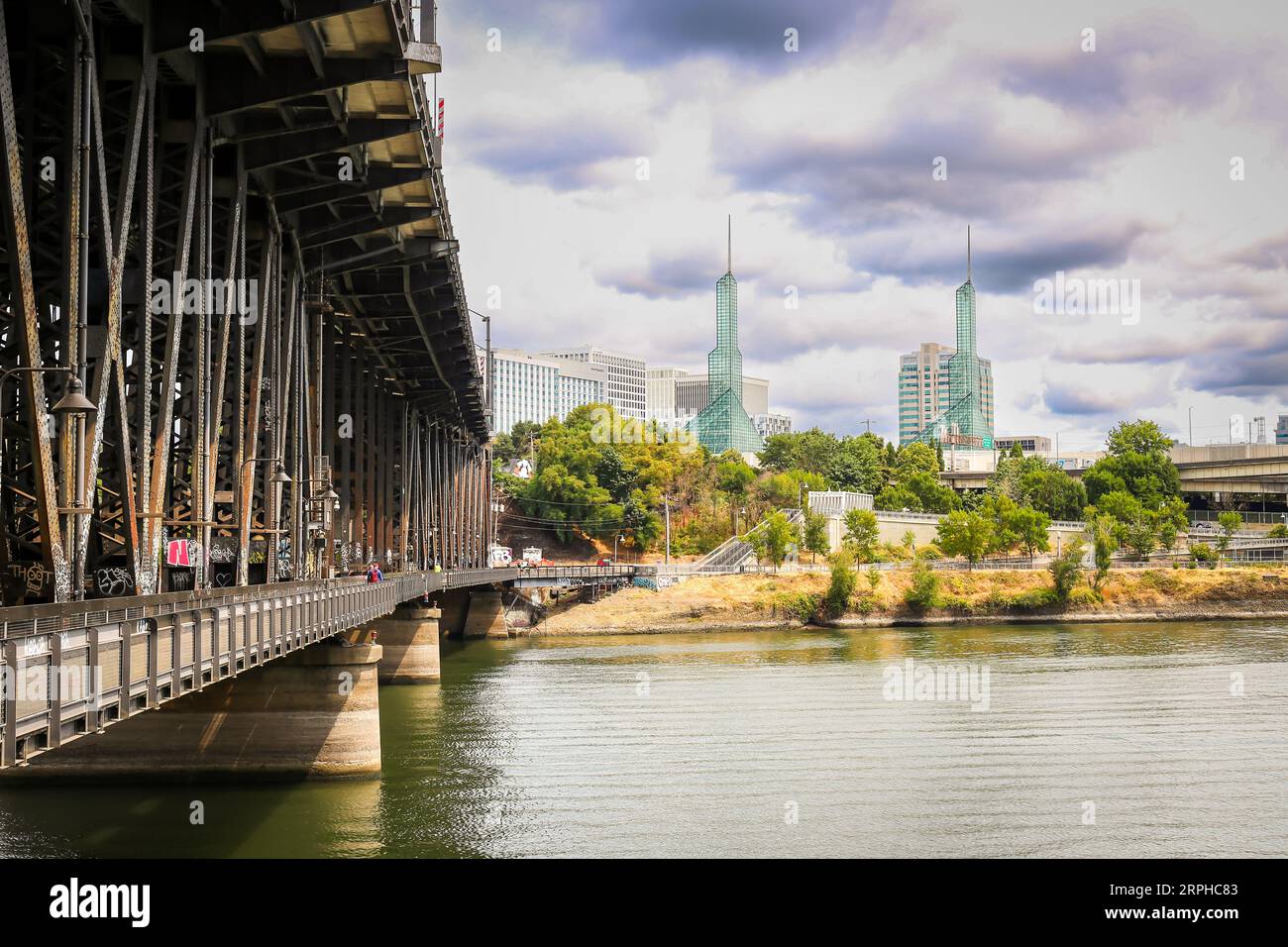 Les gens marchent et font du vélo sur le pont N Steel Bridge dans le centre-ville de Portland Oregon, en bord de mer, avec le centre de congrès de l'Oregon en arrière-plan Banque D'Images
