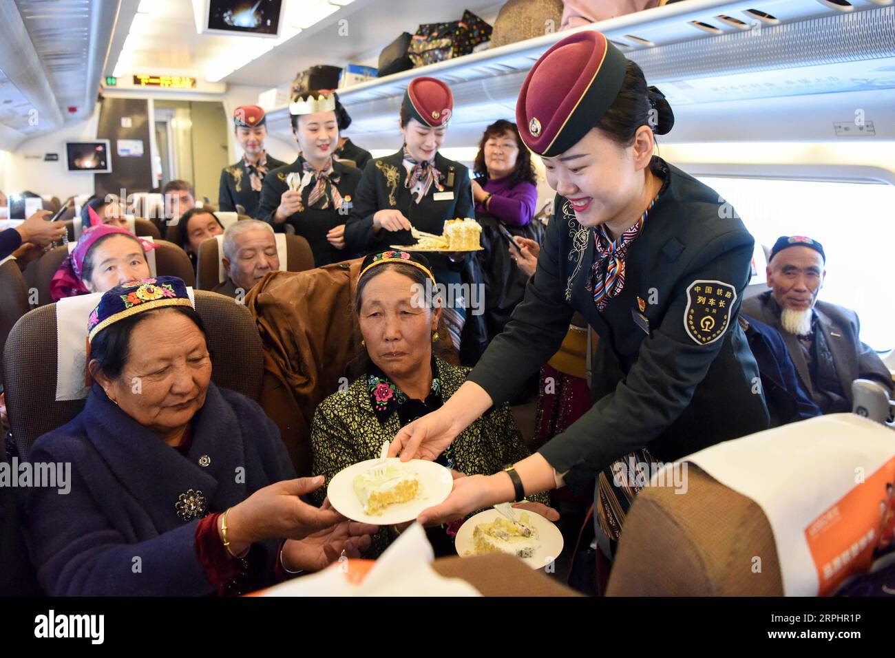 191116 -- URUMQI, le 16 novembre 2019 -- les hôtesses servent des gâteaux aux passagers pour célébrer le cinquième anniversaire de l'exploitation de la section Xinjiang de la ligne de chemin de fer à grande vitesse Lanxin sur le train D8804 d'Urumqi à Hami dans la région autonome ouygur du Xinjiang du nord-ouest de la Chine, le 16 novembre 2019. Samedi marque la cinquième année d’exploitation de la première liaison ferroviaire à grande vitesse du Xinjiang qui a transporté 30,75 millions de passagers. À l'heure actuelle, les trains effectuent 43 allers-retours par jour dans la section du Xinjiang de Lanxin à grande vitesse. CHINE-XINJIANG-TRANSPORT-CHEMIN DE FER À GRANDE VITESSE-5E ANNIVERSAIRE CN DI Banque D'Images