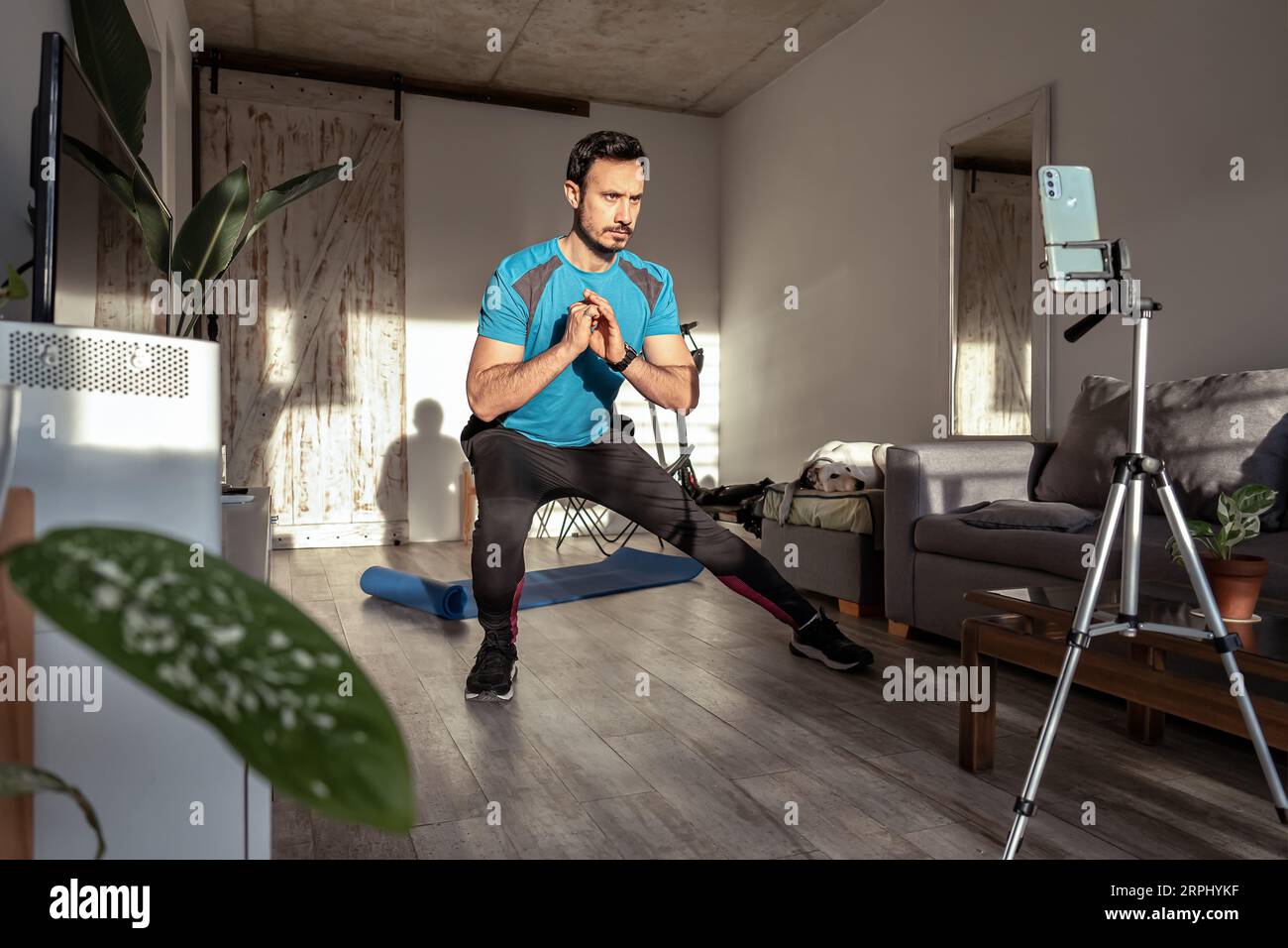 Homme latino faisant une vidéo de fitness pour les médias sociaux. Créateur de contenu ou influenceur masculin pour l'entraînement de fitness en ligne. Banque D'Images