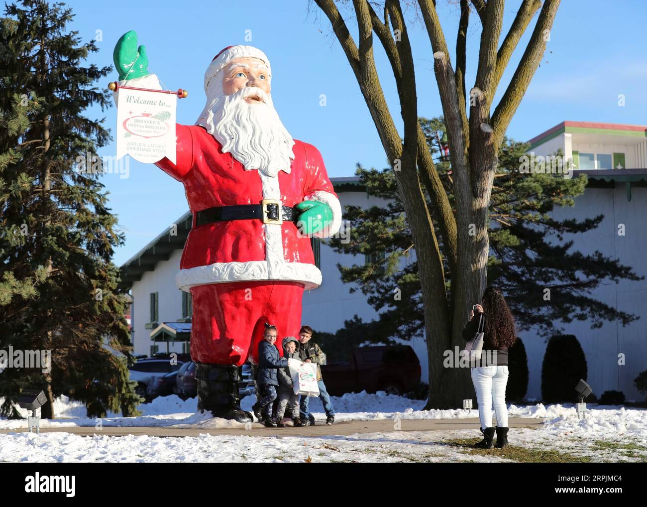 191214 -- BEIJING, le 14 décembre 2019 -- Une mère prend des photos de ses enfants avec une statue du Père Noël de 5 mètres de haut devant le Bronner s Christmas Wonderland à Frankenmuth, dans l'État du Michigan, aux États-Unis, le 16 novembre 2019. Xinhua Headlines : Across the Pacific -- Un conte de deux marchés de Noël WangxPing PUBLICATIONxNOTxINxCHN Banque D'Images