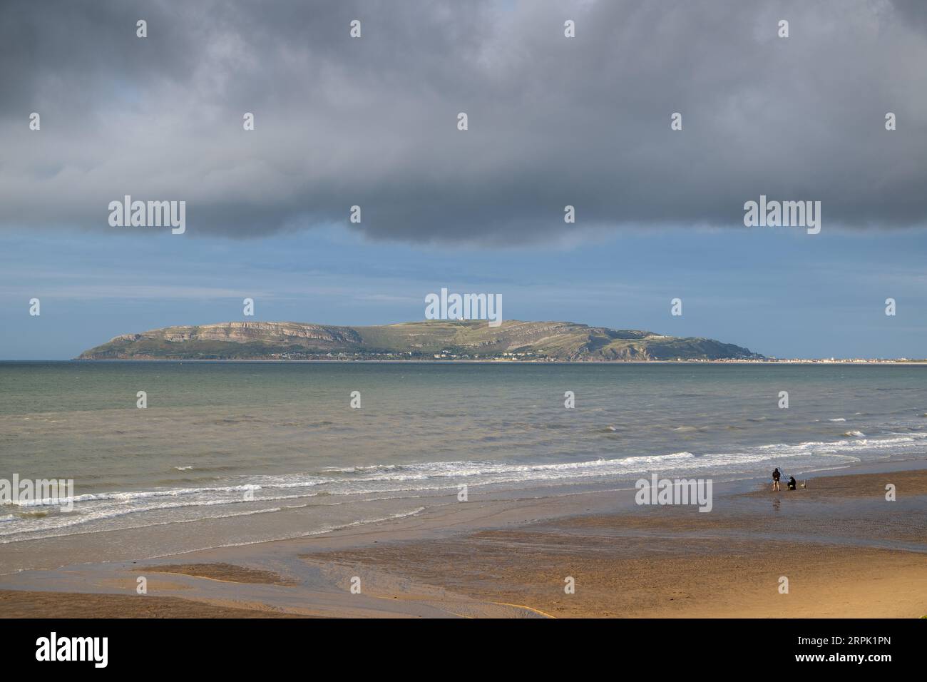 Plage à Penmaenmawr dans le nord du pays de Galles, regardant vers Llandudno et le Grand Orme, par une agréable soirée d'été. Banque D'Images