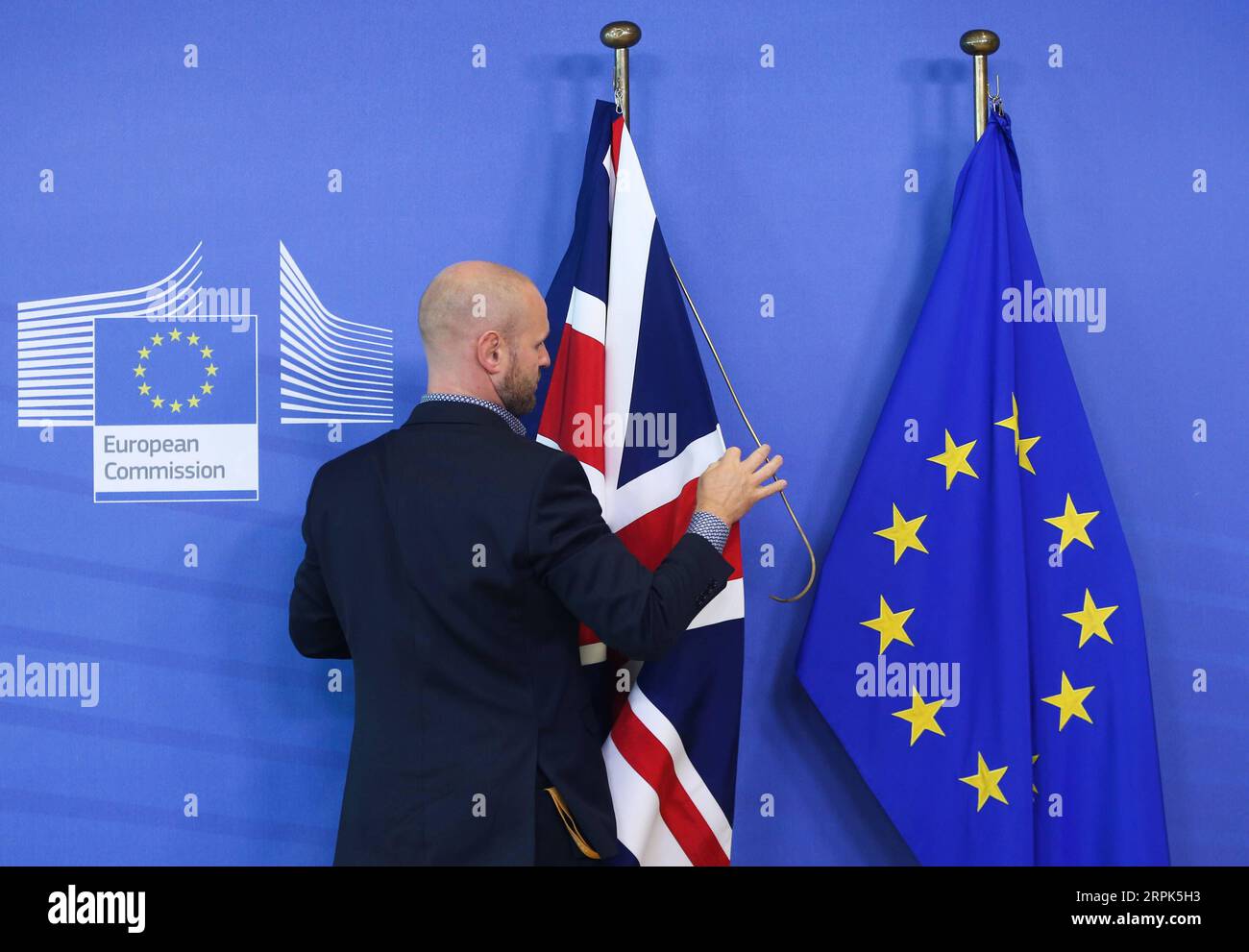 191230 -- PÉKIN, le 30 décembre 2019 -- Un membre du personnel arrange les drapeaux du Royaume-Uni et de l'UE avant la rencontre entre le président de la Commission européenne Jean-Claude Juncker et le Premier ministre britannique Boris Johnson au siège de la Commission européenne à Bruxelles, en Belgique, le 17 octobre 2019. Le Brexit prolongé révèle les failles institutionnelles des démocraties occidentales le 28 octobre, l Union européenne a accepté la demande de la Grande-Bretagne de reporter la date du Brexit au 31 janvier 2020, troisième prolongation du Brexit. Theresa May a démissionné de son poste de Premier ministre britannique après que son accord sur le Brexit ait été rejeté à plusieurs reprises par TH Banque D'Images