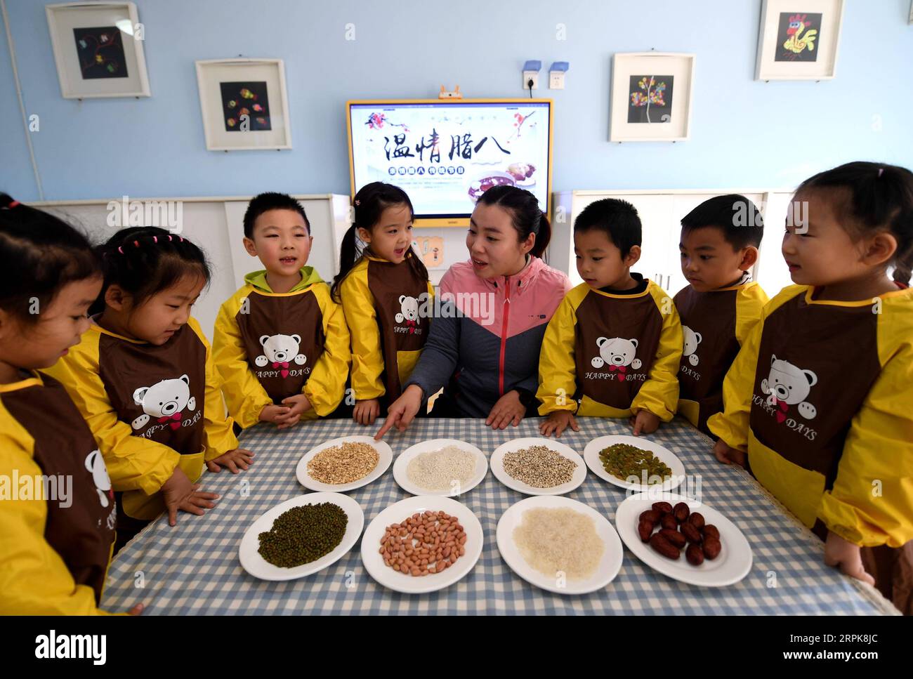 200102 -- SHIJIAZHUANG, le 2 janvier 2020 -- Un enseignant expose des ingrédients de bouillie de Laba à des élèves d'une école maternelle à Shijiazhuang, dans la province du Hebei, dans le nord de la Chine, le 2 janvier 2020. La fête de Laba, littéralement le huitième jour du 12e mois lunaire, est considérée comme un prélude à la fête du printemps, ou nouvel an lunaire chinois. Il est de coutume de manger de la bouillie Laba ce jour-là. CHINA-SHIJIAZHUANG-LABA FESTIVAL-JARDIN D'ENFANTS CN WANGXXIAO PUBLICATIONXNOTXINXCHN Banque D'Images