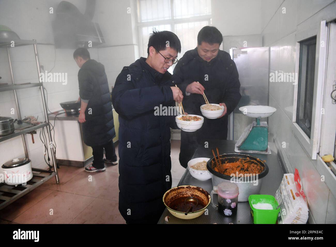 200109 -- BAOJI, 9 janvier 2020 -- Liu Xinggang L, front, le directeur de la gare de Qingshiya et l'officier en service Zhang Yan 1st R préparent des déjeuners pour les membres du personnel de la gare de Qingshiya dans la ville de Baoji, dans la province du Shaanxi du nord-ouest de la Chine, le 7 janvier 2020. La gare de Qingshiya est au sommet des montagnes de Qinling sur le premier chemin de fer électrifié de Chine, Baoji - Chengdu Railway. Entourée de falaises abruptes, la station des nuages se compose de seulement deux voies et sert de court arrêt pour les trains qui passent sur le chemin de fer. Aussi petite qu'elle soit, la station possède tous les organes vitaux. Pour garantir Banque D'Images