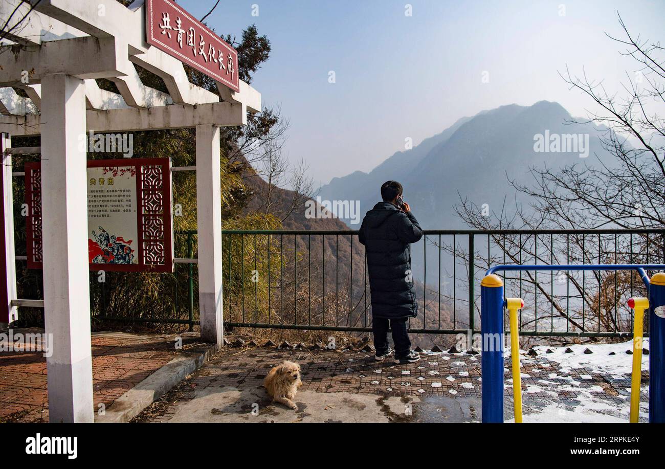 200109 -- BAOJI, le 9 janvier 2020 -- un officier de la gare de Qingshiya passe un appel téléphonique près de la falaise avec un signal téléphonique faible dans la ville de Baoji, dans la province du Shaanxi au nord-ouest de la Chine, le 7 janvier 2020. La gare de Qingshiya est au sommet des montagnes de Qinling sur le premier chemin de fer électrifié de Chine, Baoji - Chengdu Railway. Entourée de falaises abruptes, la station des nuages se compose de seulement deux voies et sert de court arrêt pour les trains qui passent sur le chemin de fer. Aussi petite qu'elle soit, la station possède tous les organes vitaux. Pour garantir le fonctionnement de la gare, des membres du personnel de la gare travaillent sur Banque D'Images