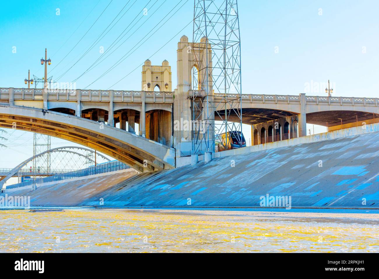 Le train passe sous le pont de la 6th Street le long de la rivière Los Angeles. Banque D'Images