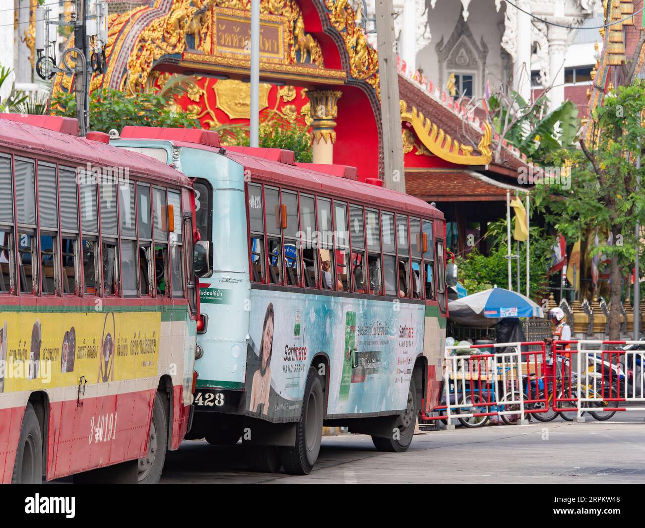 Des bus urbains attendent devant la porte du Wat Hua Lam Phong, un temple bouddhiste dans le centre-ville de Bangkok, Thaïlande. Banque D'Images