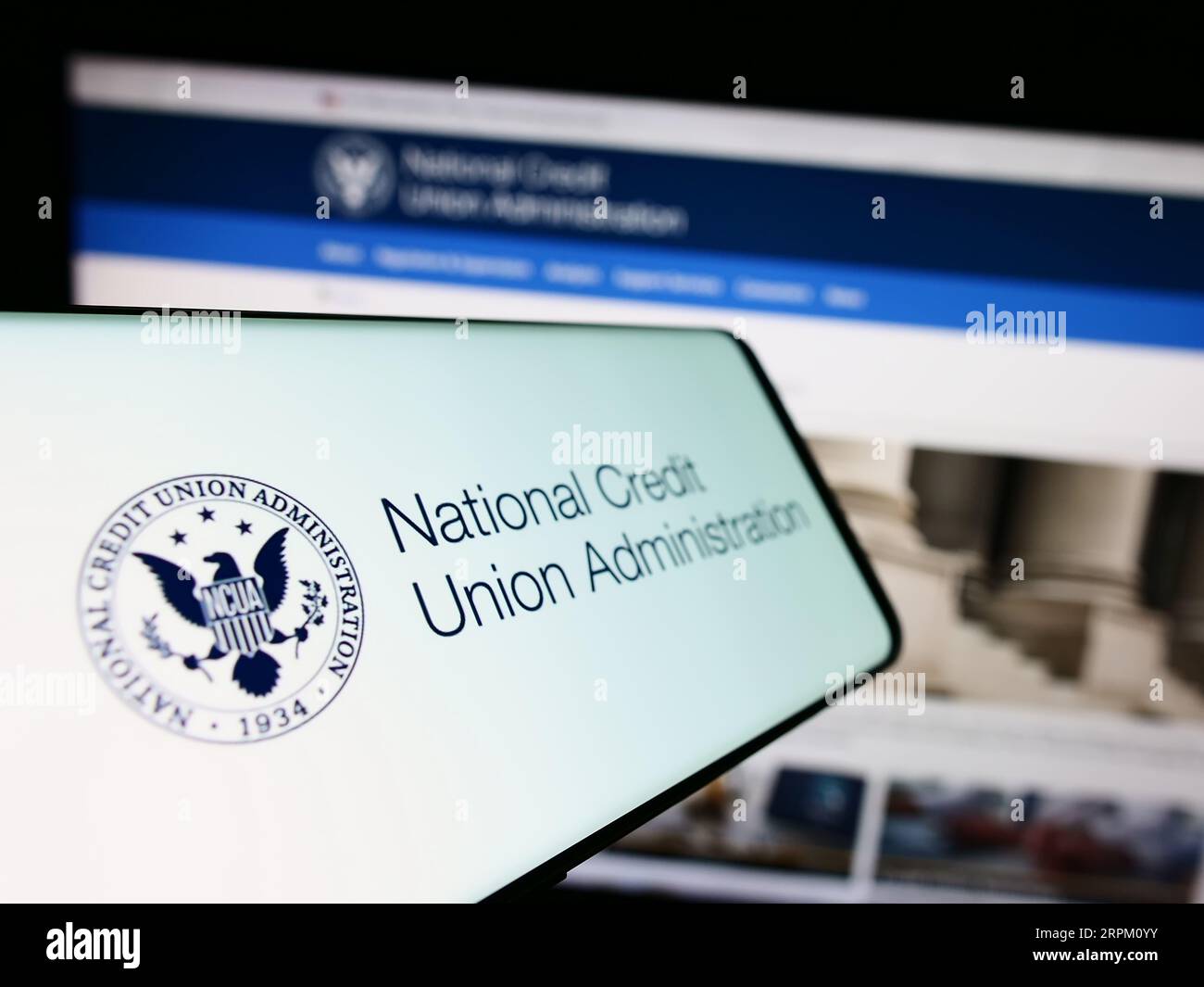phong mobile avec sceau de National Credit Union Administration (NCUA) sur l'écran devant le site Web. Concentrez-vous sur le centre gauche de l'écran du téléphone. Banque D'Images
