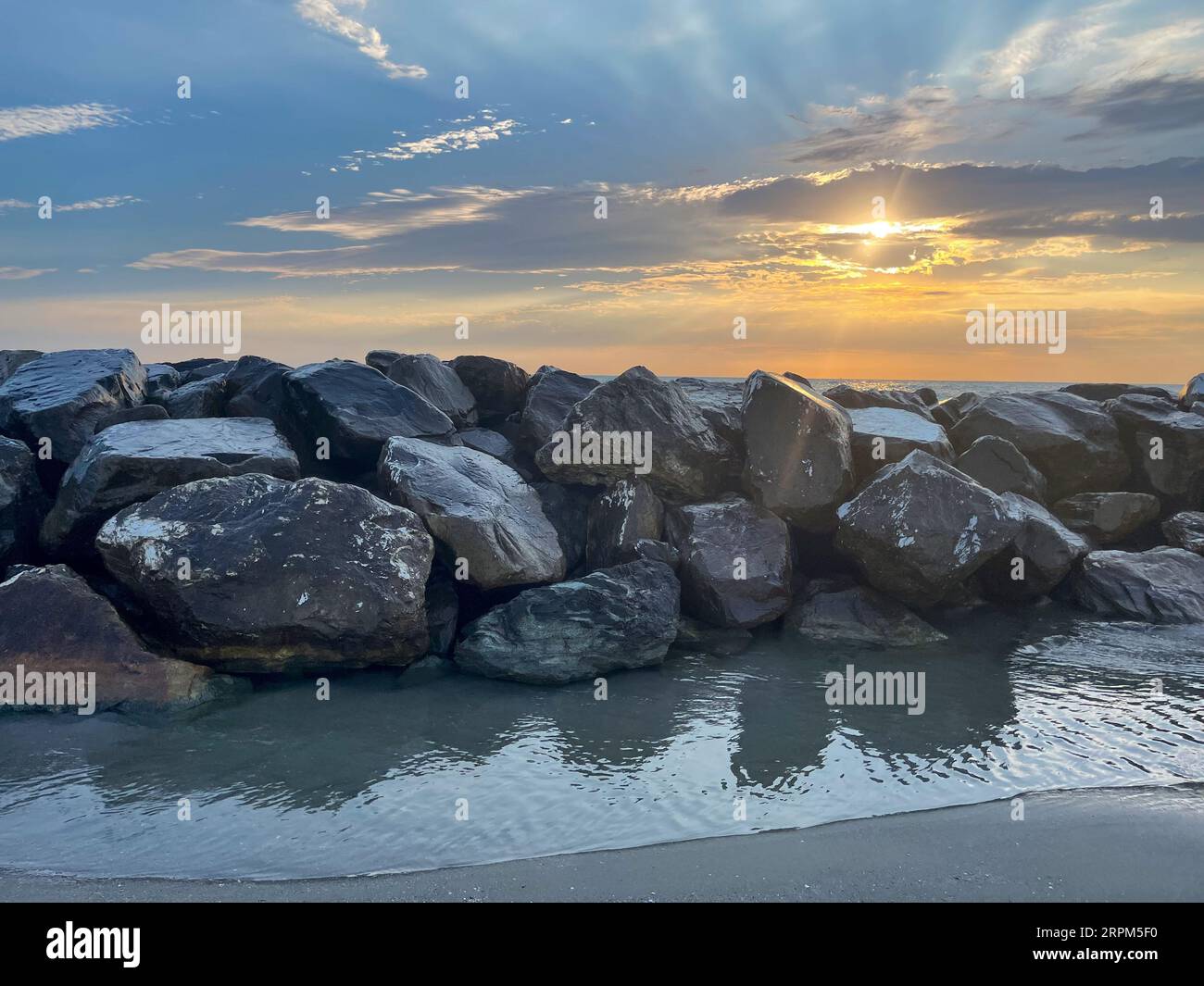 coucher de soleil sur la plage avec des rochers en italie Banque D'Images