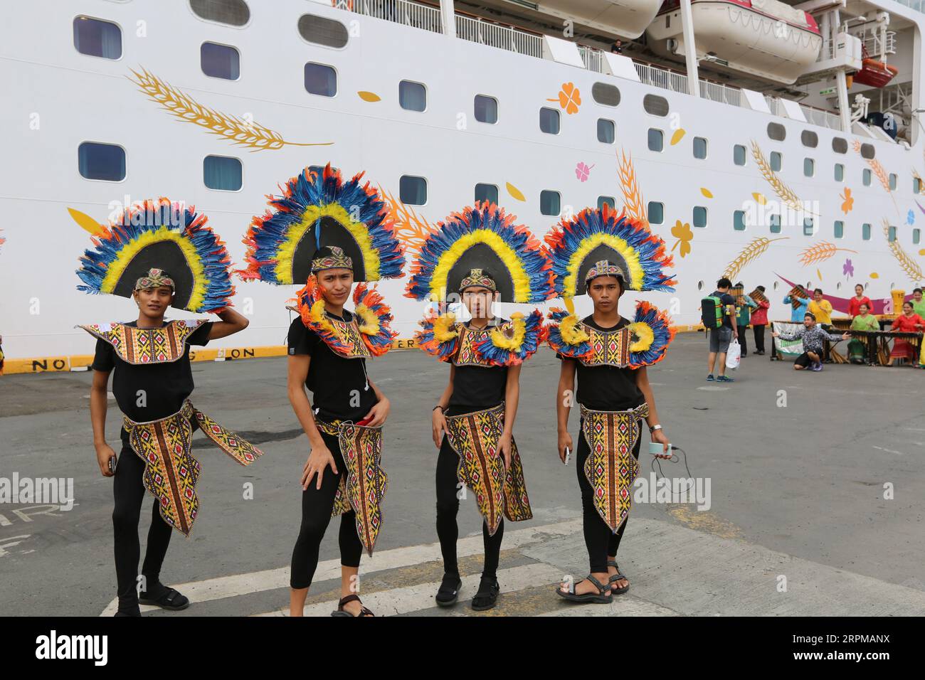 Fête de bienvenue sur le thème de la fête philippine pour bateau de croisière à Manille Pier : musiciens avec des instruments en bambou, danseurs philippins, higantes, drapeaux Banque D'Images