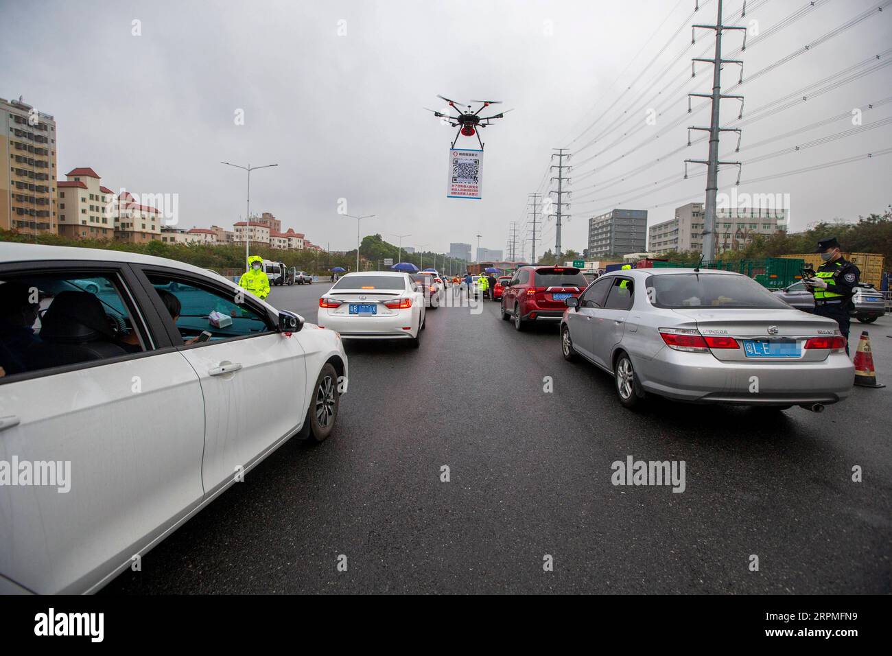 200211 -- SHENZHEN, 11 février 2020 Xinhua -- Un drone portant une plaque de code QR est vu près d'une station de péage d'autoroute à Shenzhen, dans la province du Guangdong du sud de la Chine, le 11 février 2020. Comme mesure pour aider à prévenir et à contrôler le nouveau coronavirus, un système de registre en ligne pour les véhicules qui reviennent à Shenzhen a été mis en service depuis février 8. Pour augmenter l’efficacité, les policiers locaux ont utilisé des drones pour porter un code QR aux sorties de l’autoroute afin que les conducteurs puissent s’enregistrer avec moins de contact avec d’autres personnes. Photo de Lai Li/Xinhua CHINA-SHENZHEN-NCP-QR CODE-REGISTER CN PUBLICATIONxNOTxINxCHN Banque D'Images