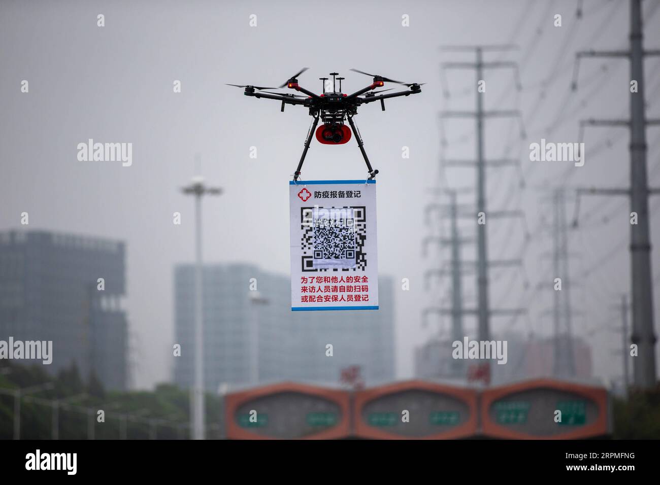 200211 -- SHENZHEN, 11 février 2020 Xinhua -- Un drone portant une plaque de code QR est vu près d'une station de péage d'autoroute à Shenzhen, dans la province du Guangdong du sud de la Chine, le 11 février 2020. Comme mesure pour aider à prévenir et à contrôler le nouveau coronavirus, un système de registre en ligne pour les véhicules qui reviennent à Shenzhen a été mis en service depuis février 8. Pour augmenter l’efficacité, les policiers locaux ont utilisé des drones pour porter un code QR aux sorties de l’autoroute afin que les conducteurs puissent s’enregistrer avec moins de contact avec d’autres personnes. Photo de Lai Li/Xinhua CHINA-SHENZHEN-NCP-QR CODE-REGISTER CN PUBLICATIONxNOTxINxCHN Banque D'Images