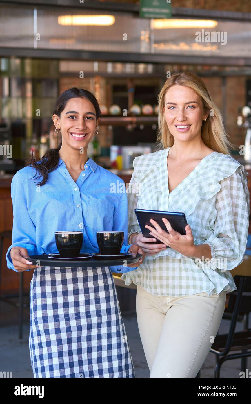 Portrait de Manager féminin avec tablette numérique et serveuse travaillant dans un restaurant ou un café Banque D'Images