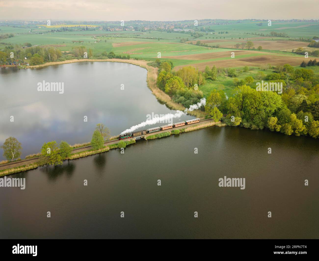 Le train traditionnel de la Loessnitzgrundbahn traverse le barrage dans l'étang de Dippelsorfer Banque D'Images