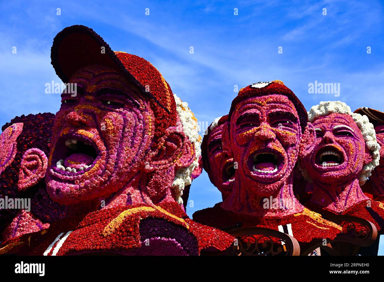 Visages criants d'êtres humains ; un des chars de la Zundert Flower Parade 2023 Banque D'Images