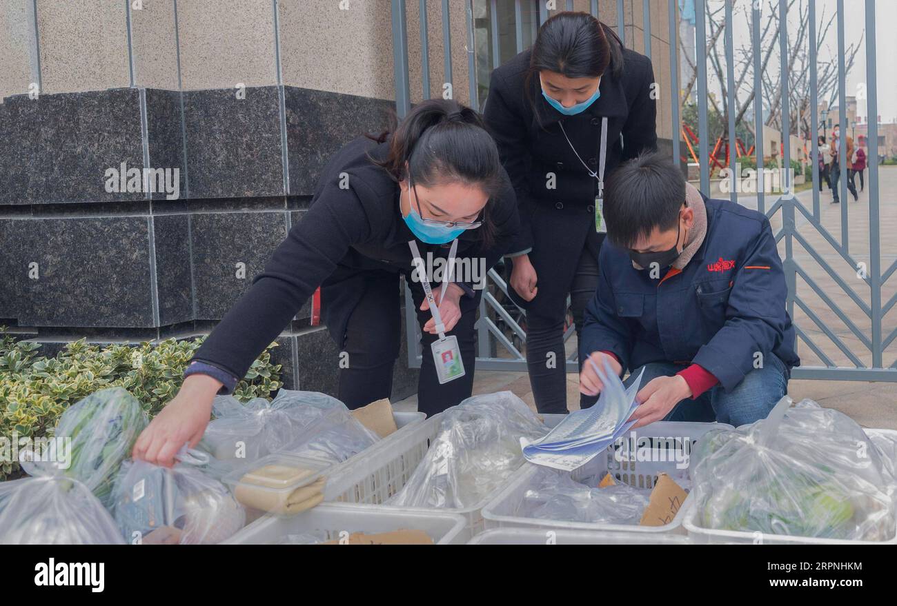 200229 -- SANMENXIA, le 29 février 2020 -- un membre du personnel d'une plateforme de commerce électronique et des travailleurs communautaires vérifient la réception des légumes commandés à la porte d'une communauté, à Sanmenxia, province du Henan au centre de la Chine, le 28 février 2020. Récemment, Sanmenxia a réalisé un projet visant à assurer l’approvisionnement en légumes des résidents grâce à un système de distribution communautaire développé par une plateforme de commerce électronique. La plate-forme transporte les légumes des bases de plantation des agriculteurs locaux vers les communautés résidentielles. Les résidents locaux récupèrent leurs commandes séparément. De cette façon, les résidents peuvent acheter des légumes frais avec z Banque D'Images