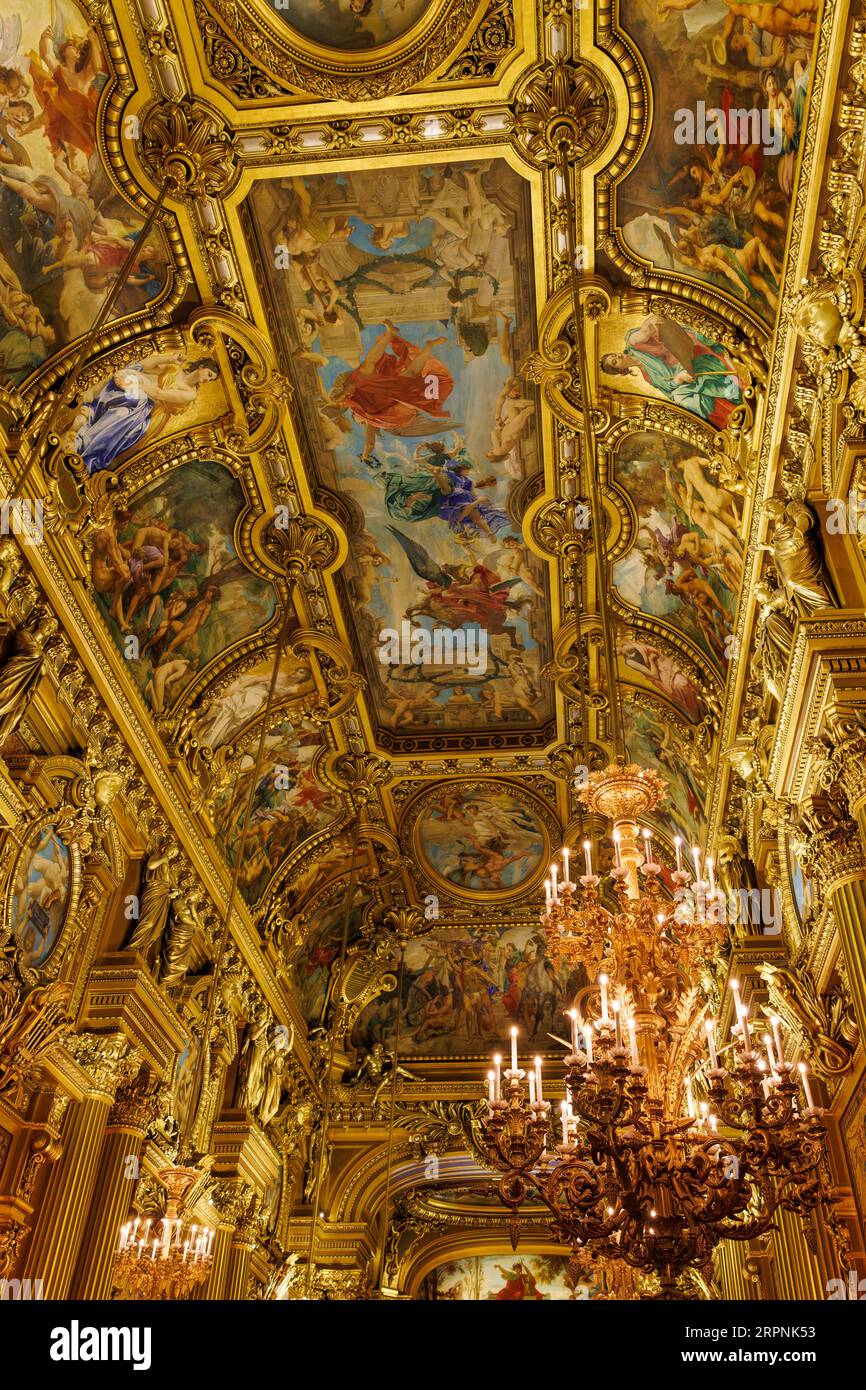 Un luxueux plafond peint doré et orné dans une salle grandiose, créant une atmosphère somptueuse et opulente Banque D'Images