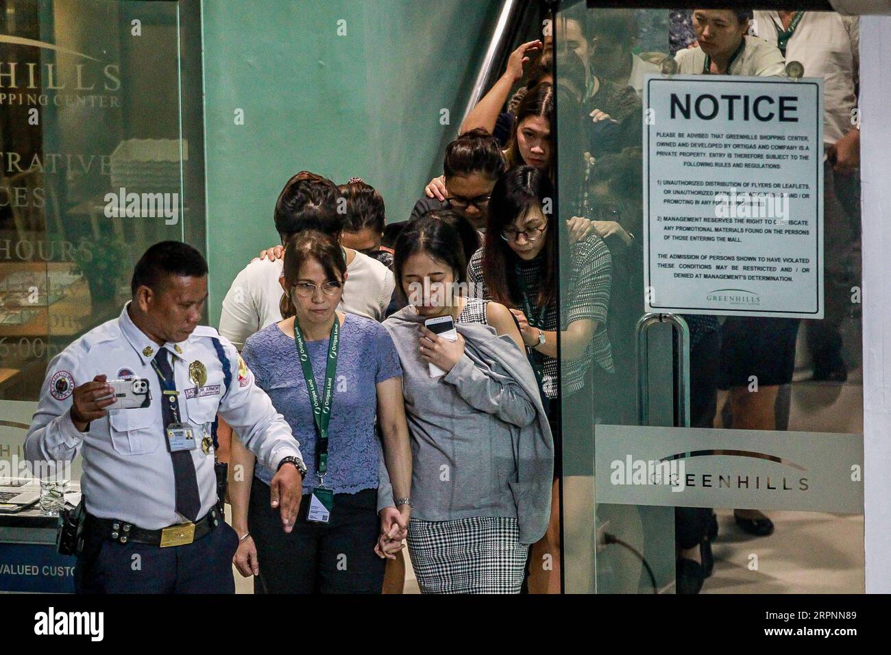 200302 -- MANILLE, le 2 mars 2020 -- Un garde de sécurité conduit les otages en lieu sûr alors qu'ils sont libérés lors de la fusillade et de la prise d'otages à San Juan City, Metro Manila, Philippines, le 2 mars 2020. La police philippine a mis fin à un incident de prise d'otages de 10 heures dans le Grand Manille lundi, persuadant le tireur de libérer tous les otages et de se rendre aux autorités. Environ 30 personnes prises en otage par le tireur ont été relâchées et ont quitté le V-Mall dans la ville de San Juan de Metro Manila. PHILIPPINES-MANILLE-INCIDENT D'OTAGES ROUELLExUMALI PUBLICATIONxNOTxINxCHN Banque D'Images