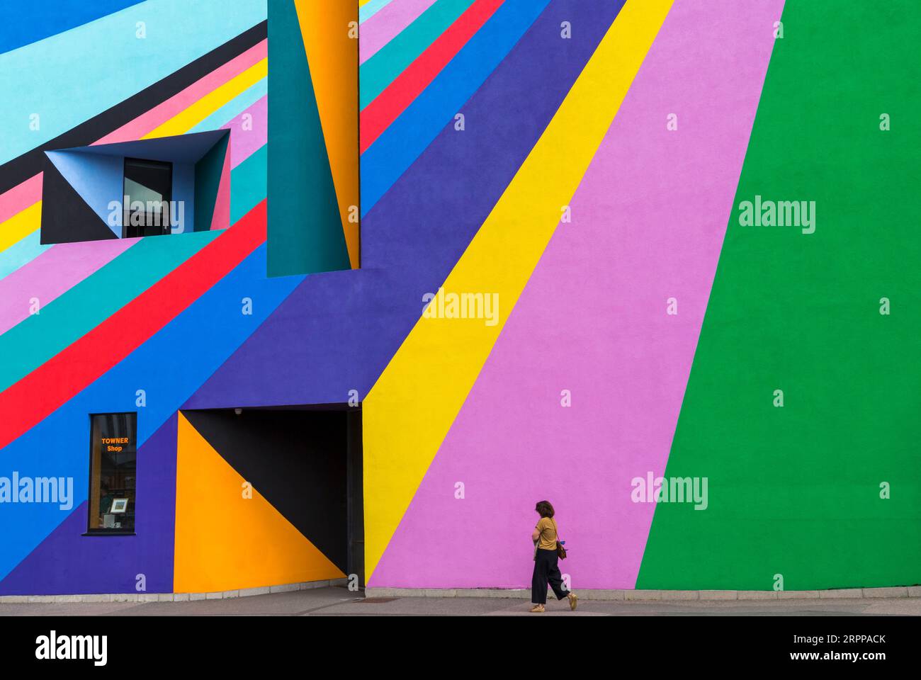 Une femme passe devant la Towner Art Gallery avec une œuvre colorée Dance Diagonal de l'artiste allemand Lothar Götz à Eastbourne, East Sussex, Royaume-Uni en septembre Banque D'Images