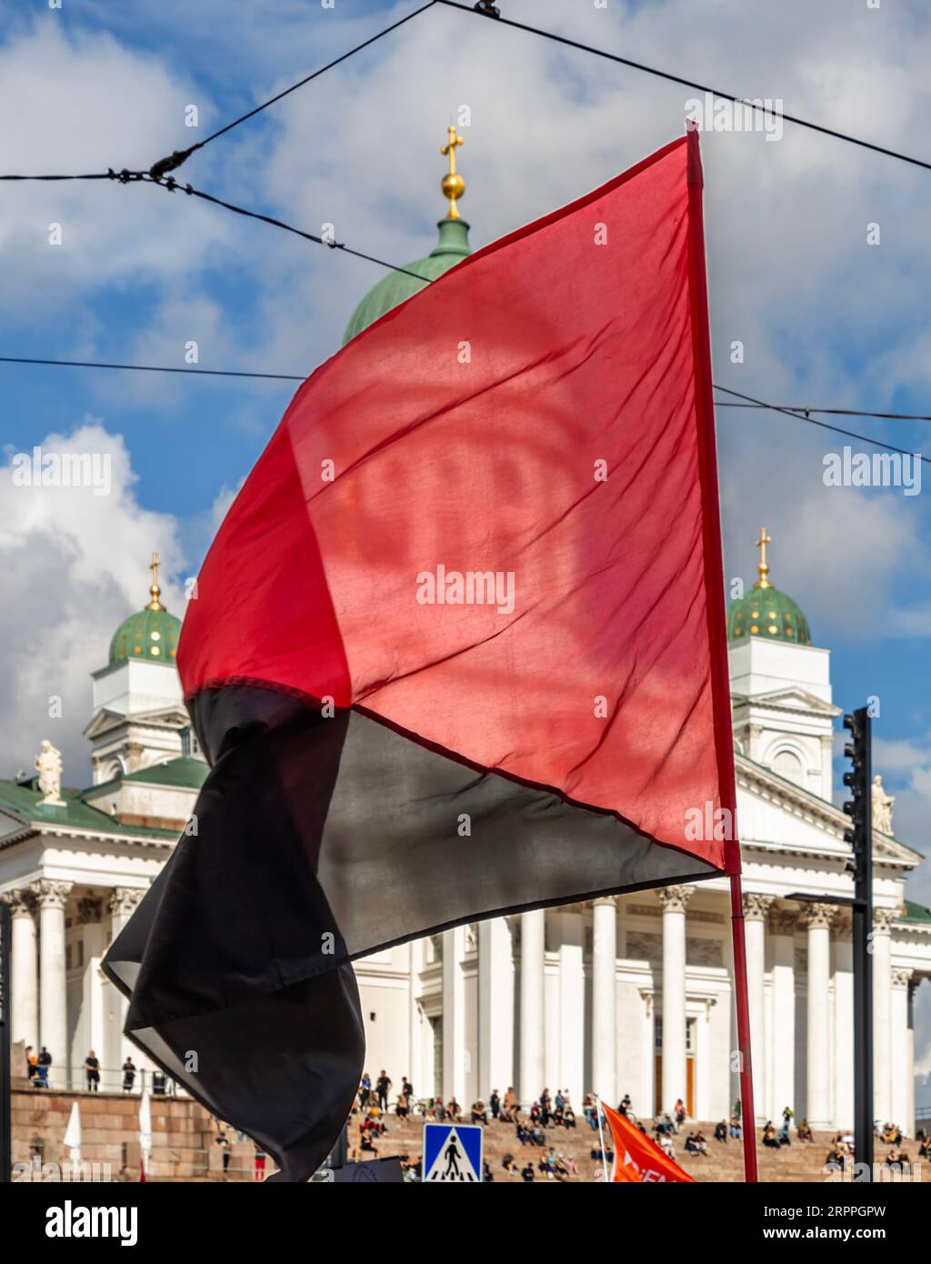 Drapeau rouge et noir flotté devant la cathédrale d’Helsinki pendant la « fin du silence ! » manifestation contre le racisme et le fascisme. Banque D'Images