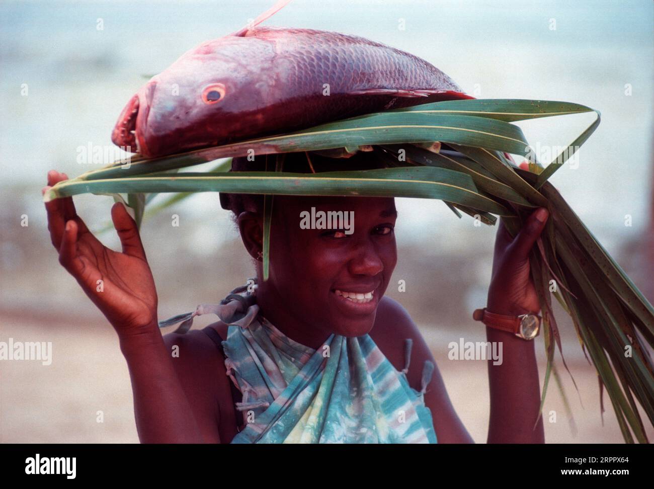 Femme africaine portant un poisson au-dessus de sa tête, plage de Kilifi, Kenya Banque D'Images