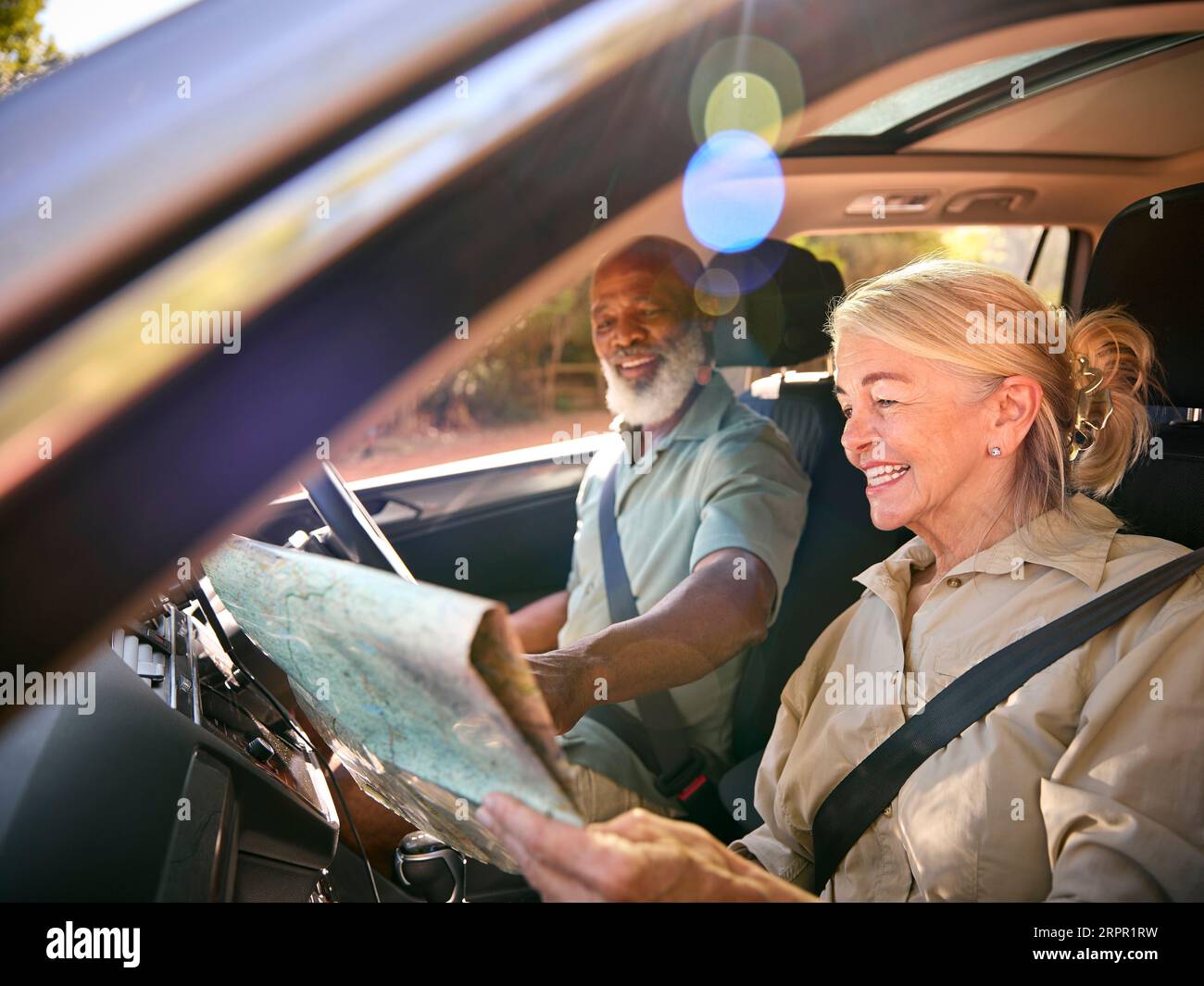 Couple senior en excursion d'une journée conduite dans la carte de lecture de voiture Banque D'Images