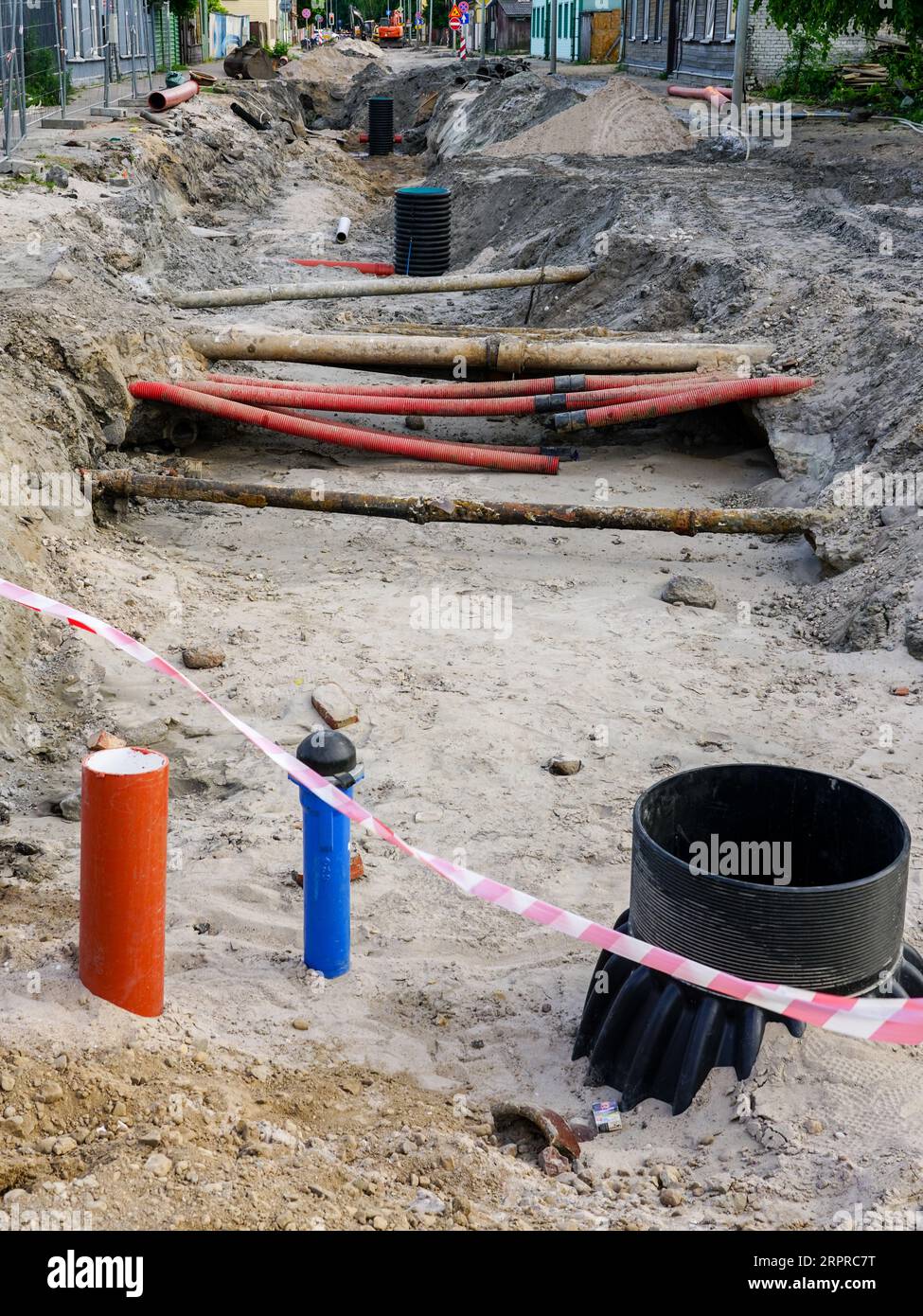 Vue de reconstruction de rue avec tranchée profonde, tuyaux souterrains anciens et remplacés, nouveau puits en plastique vertical Banque D'Images