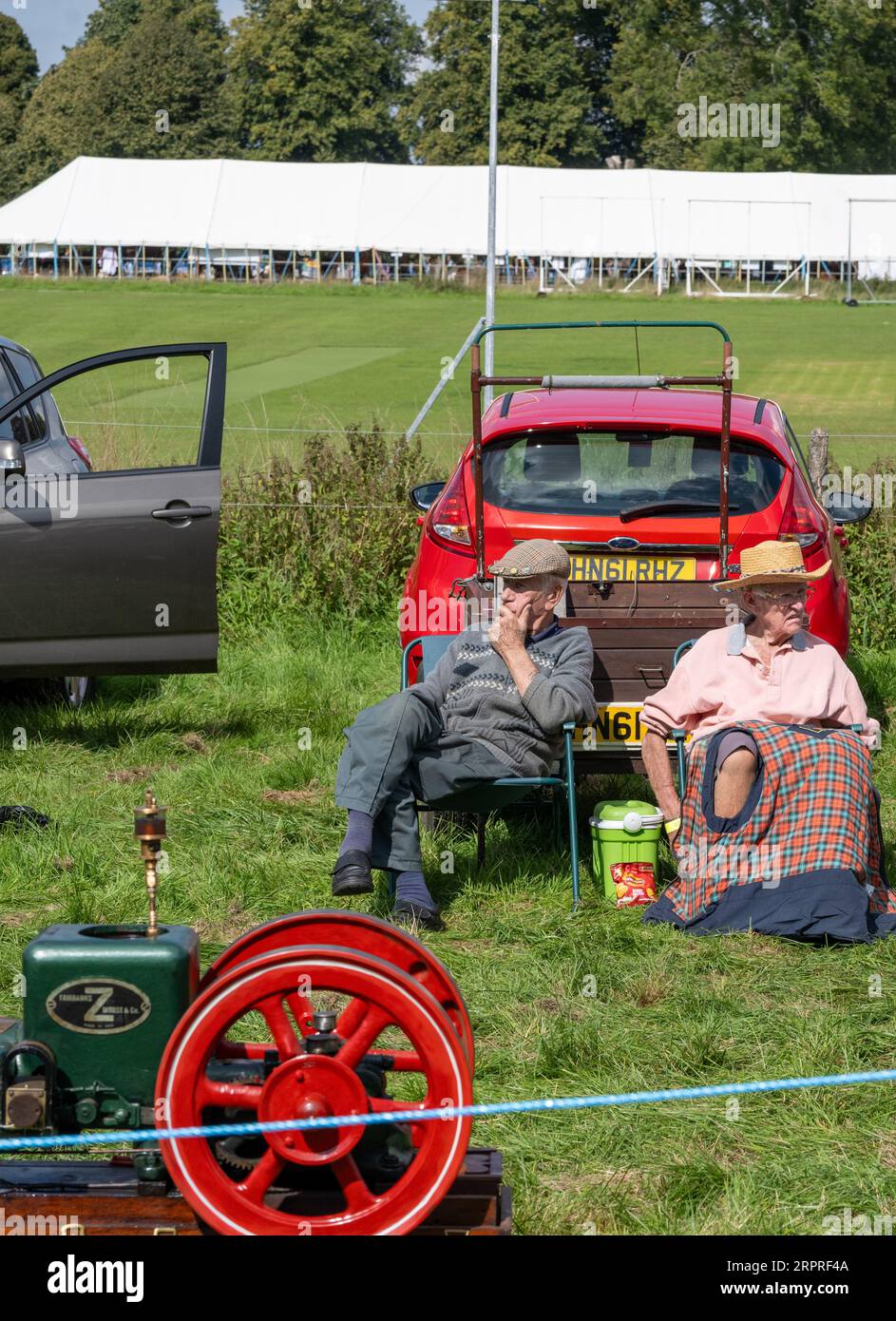 Un couple plus âgé veille sur leur moteur stationnaire vintage. Alresford and District Agricultural Show, Alresford, Hampshire, Royaume-Uni Banque D'Images