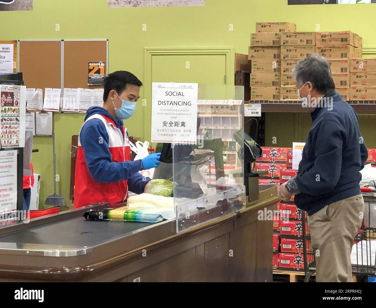 200404 -- DALLAS , le 4 avril 2020 -- le client et le caissier du magasin portent des masques à l'intérieur d'un supermarché chinois à Plano, une ville de banlieue de Dallas, Texas, États-Unis, le 3 avril 2020. Le président américain Donald Trump a déclaré vendredi que les Centers for Disease Control and Prevention CDC recommandent désormais aux Américains de porter des couvre-visage en tissu pour se protéger contre le COVID-19. Le CDC conseille l'utilisation d'un couvre-visage en tissu non médical comme mesure de santé volontaire, a déclaré Trump lors d'un briefing à la Maison Blanche. Il est volontaire. Ils ont suggéré pendant un certain temps. Photo de /Xinhua U.S.-TEXAS-DALLAS-MASK-COVID-19 Banque D'Images