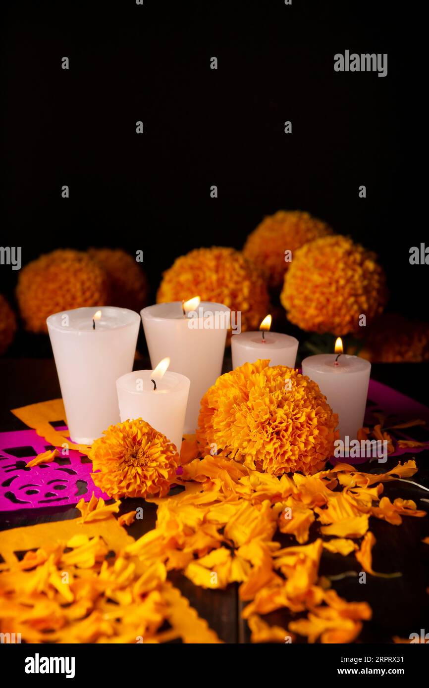 Bougies aux fleurs d'orange Cempasuchil ou Marigold.(Tagetes erecta) et Papel Picado.Décoration traditionnellement utilisée dans les autels pour la célébration de Banque D'Images
