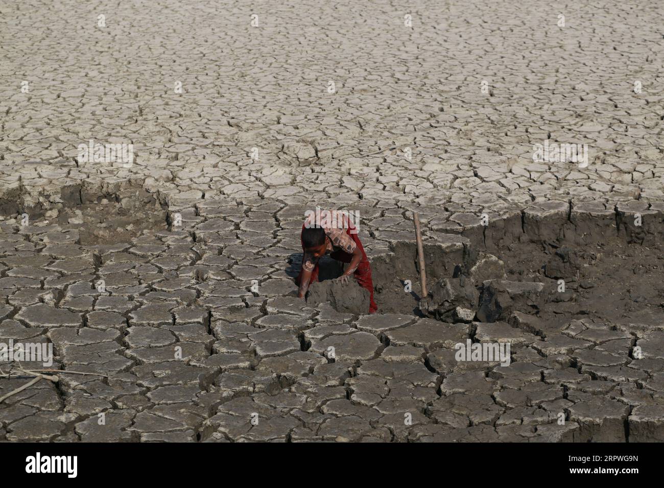 Un enfant travaille alors qu’il répare le barrage après qu’un cyclone ait frappé les zones côtières du Bangladesh le 5 janvier 2021. Des millions de personnes sont touchées par la crise climatique dans les ceintures côtières du Bangladesh. Banque D'Images