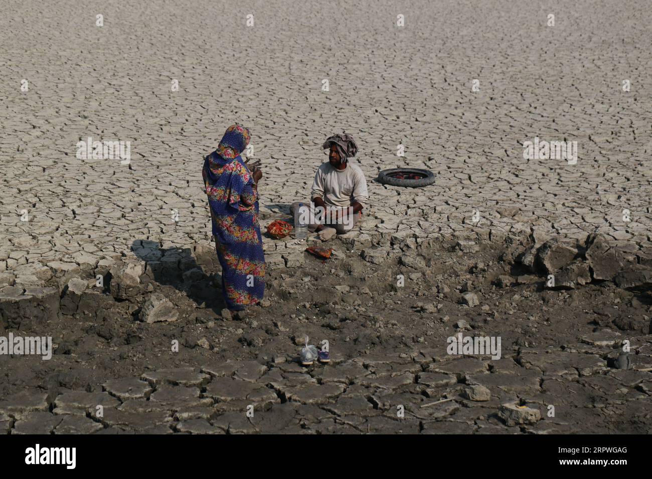 Les ouvriers se reposent alors qu’ils réparent le barrage après qu’un cyclone ait frappé les zones côtières du Bangladesh le 5 janvier 2021. Des millions de personnes sont touchées par la crise climatique dans les ceintures côtières du Bangladesh. Banque D'Images