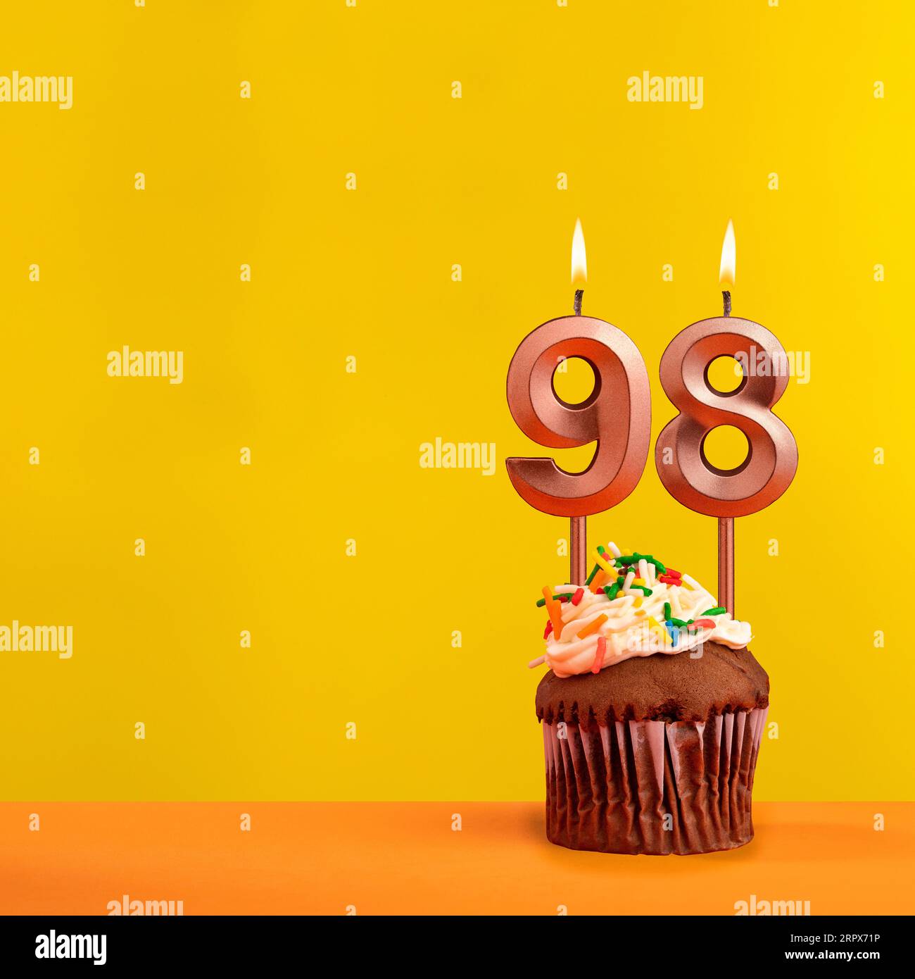 Bougie d'anniversaire numéro 98 - célébration sur fond jaune Banque D'Images