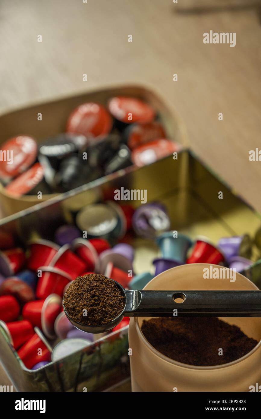 Nature morte avec un récipient plein de café moulu et une boîte avec des capsules de différents types de café Banque D'Images