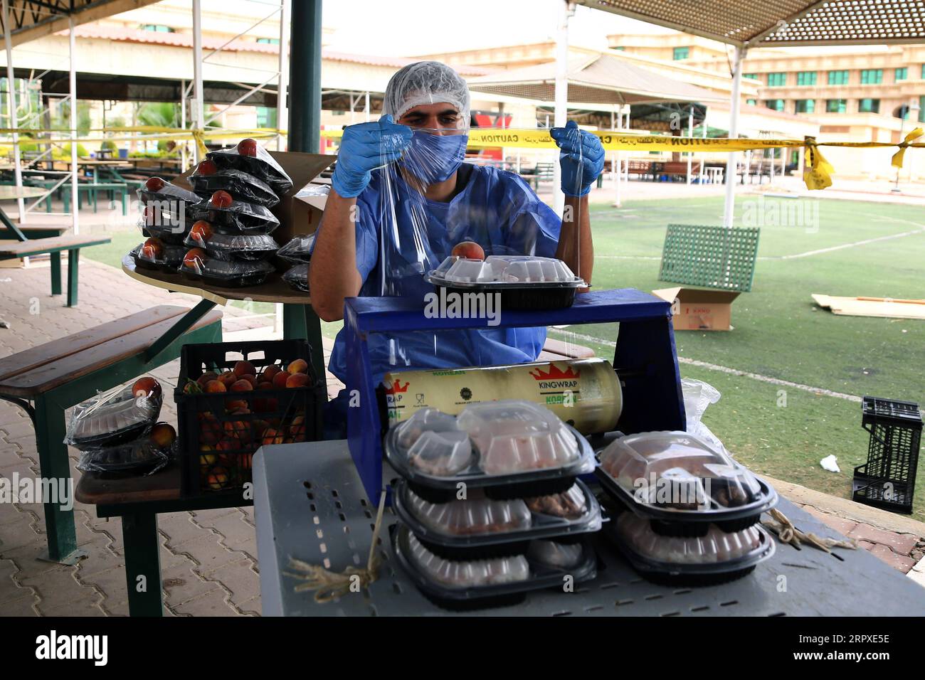 200519 -- LE CAIRE, le 19 mai 2020 -- Un homme prépare des repas gratuits à emporter au Caire, en Égypte, le 15 mai 2020. Votre repas gratuit est prêt. Prenez-le et mangez à la maison, lit un grand panneau placé dans une rue du quartier de Dar el-Salam au Caire, encourageant les pauvres à emporter de la nourriture gratuite pour l'Iftar, les repas rapides, pendant le mois sacré musulman du Ramadan. POUR ALLER AVEC la fonctionnalité : les Égyptiens remplacent les banquets de charité du Ramadan par des repas à emporter gratuits sur le coronavirus préoccupations EGYPTE-CAIRE-COVID-19-RAMADAN-REPAS SANS AhmedxGomaa PUBLICATIONxNOTxINxCHN Banque D'Images