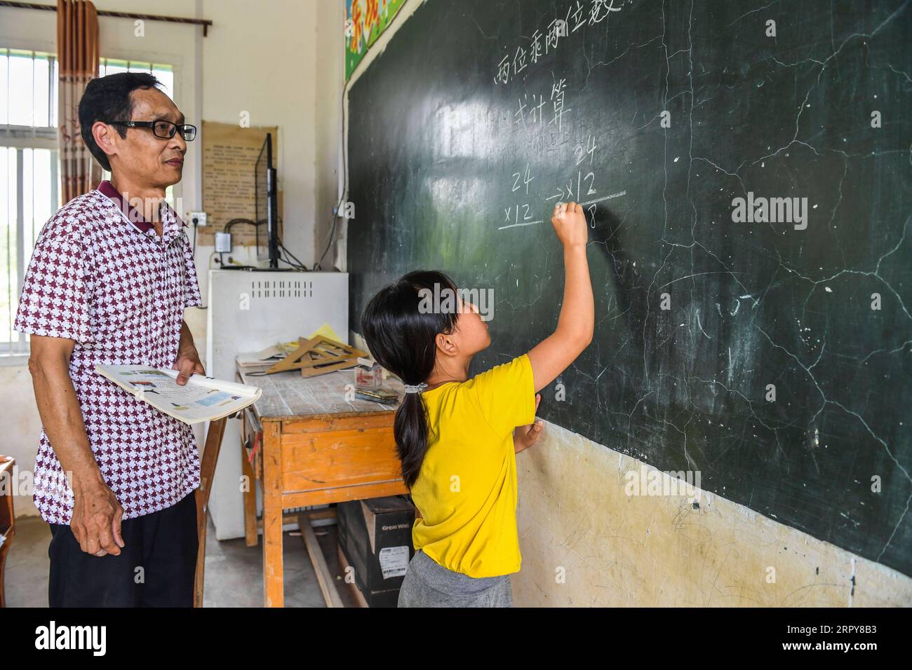 200620 -- WUXUAN, le 20 juin 2020 -- Wei Xuxi enseigne à un élève de l'école primaire Shuanggui dans la ville d'Ertang, dans le comté de Wuxuan, dans la région autonome de Guangxi Zhuang, dans le sud de la Chine, le 19 juin 2020. Wei Xuxi, un enseignant de 57 ans de la ville d'Ertang dans le comté de Wuxuan, a passé plus de 30 ans à enseigner à la campagne après avoir obtenu son diplôme d'études secondaires en 1985. Il y a 32 élèves en deux classes à l’école primaire de Shuanggui, une petite école où travaille Wei. Au lieu de bâtiments délabrés, ou de tables et chaises cassées, multimédia et de nombreux autres équipements pédagogiques avancés rendent l'école loin des pauvres et f Banque D'Images