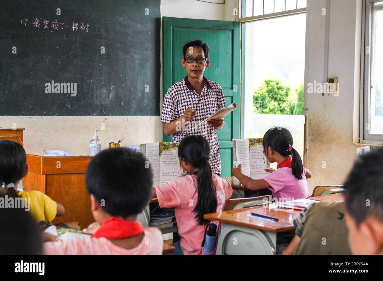 200621 -- PÉKIN, le 21 juin 2020 -- Wei Xuxi donne une leçon à l'école primaire Shuanggui dans la ville d'Ertang, dans le comté de Wuxuan, dans la région autonome de Guangxi Zhuang, dans le sud de la Chine, le 19 juin 2020. Wei Xuxi, un enseignant de 57 ans de la ville d'Ertang dans le comté de Wuxuan, a passé plus de 30 ans à enseigner à la campagne après avoir obtenu son diplôme d'études secondaires en 1985. Il y a 32 élèves en deux classes à l’école primaire de Shuanggui, une petite école où travaille Wei. Au lieu de bâtiments délabrés, ou de tables et de chaises cassées, le multimédia et de nombreux autres équipements pédagogiques avancés rendent l'école loin des pauvres et des fa Banque D'Images