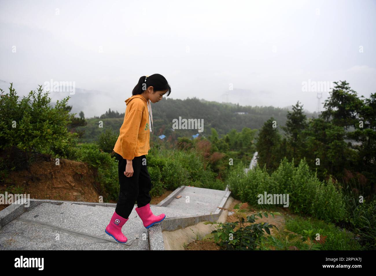 200622 -- HEFEI, le 22 juin 2020 -- Cai Qiyan passe son temps libre au sommet d'une montagne dans le village de Gaowan, dans le comté de Jinzhai, dans l'est de la Chine, dans la province d'Anhui, le 20 juin 2020. CAI Qiyan bénéficie de la vue sur les nuages coulant de l'une des plantations de thé au sommet de la montagne. Mais le plaisir a également été un luxe pour le jeune homme de 15 ans, qui a été diagnostiqué avec une scoliose congénitale. Dès son plus jeune âge, Qiyan avait trouvé extrêmement difficile de garder sa colonne vertébrale droite. Dans la profondeur des montagnes de Dabie, Qiyan a dû passer deux heures sur le chemin de l'école et du retour à la maison car il a fallu beaucoup plus de temps pour marcher avec un bo bent Banque D'Images