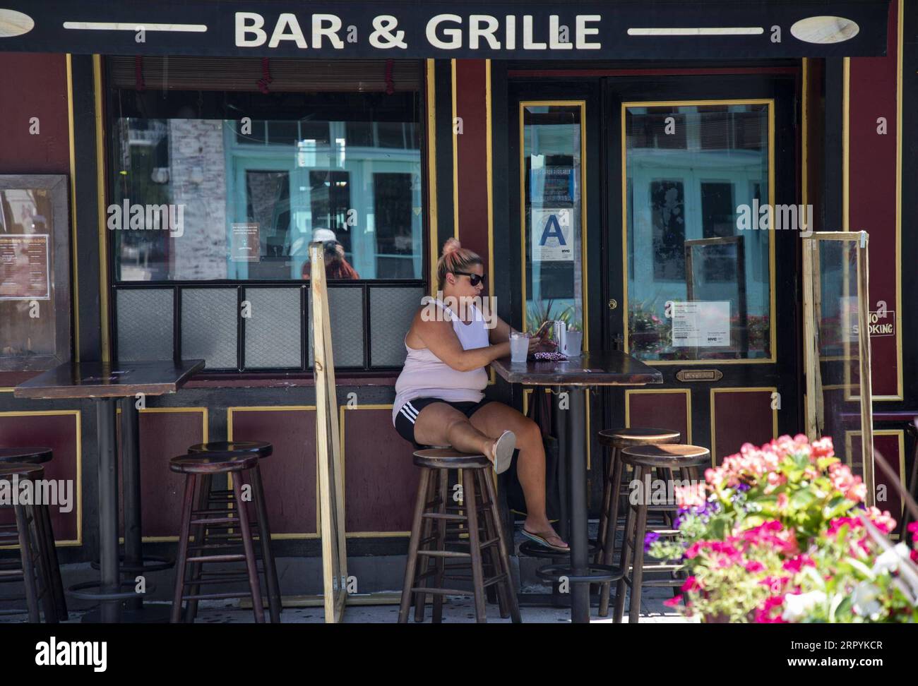 200706 -- NEW YORK, le 6 juillet 2020 -- Une femme est assise dans la salle à manger extérieure d'un restaurant à Manhattan, à New York, aux États-Unis, le 6 juillet 2020. New York City, autrefois l’épicentre de la crise du COVID-19 aux États-Unis, est entrée dans la phase trois de réouverture lundi sans reprendre les repas à l’intérieur. Les services de soins personnels, tels que les salons de manucure et les salons de massage, peuvent rouvrir après près de quatre mois de fermeture. ETATS-UNIS-NEW YORK-RÉOUVERTURE-PHASE TROIS WANGXYING PUBLICATIONXNOTXINXCHN Banque D'Images