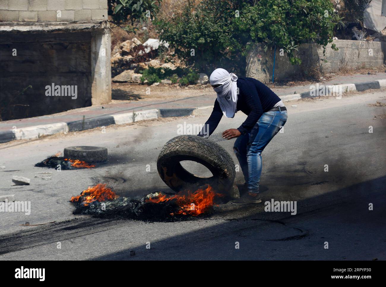 200711 -- SALFIT, le 11 juillet 2020 -- Un manifestant brûle des pneus lors d'affrontements après les funérailles d'un jeune palestinien dans le village de Kifl Haris près de la ville de Salfit en Cisjordanie, le 10 juillet 2020. Des soldats israéliens ont abattu jeudi soir un jeune palestinien en Cisjordanie, a déclaré le ministère palestinien de la Santé. L'incident a eu lieu après que des affrontements ont éclaté dans le village entre des soldats israéliens et de jeunes Palestiniens, ont indiqué des sources dans le village. Photo Ayman Nobani/Xinhua MIDEAST-SALFIT-CLASHS xiongsihao PUBLICATIONxNOTxINxCHN Banque D'Images