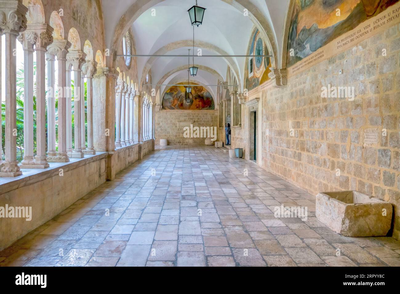 Dubrovnik, Croatie - 3 juin 2016. Un couloir intérieur du monastère franciscain médiéval dans la vieille ville, avec une cour intérieure visible. Banque D'Images