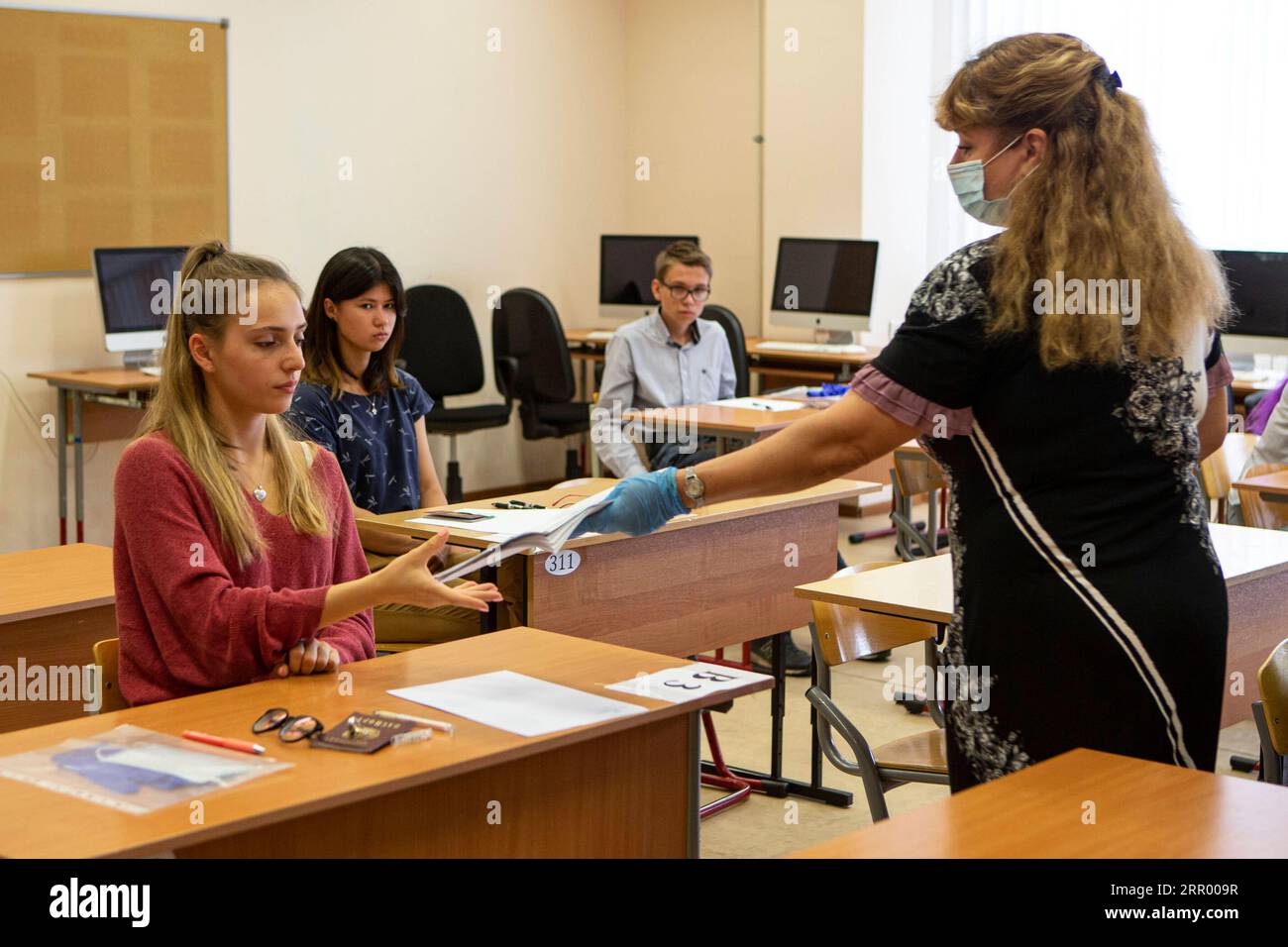 200720 -- MOSCOU, le 20 juillet 2020 Xinhua -- Un enseignant portant un masque facial distribue des documents de test aux élèves d'une salle de classe lors de l'examen d'État unifié de langue chinoise dans une école de Moscou, en Russie, le 20 juillet 2020. L’examen d’État unifié a commencé plus tard que d’habitude cette année en raison de la pandémie COVID-19. Photo de Alexander Zemlianichenko Jr/Xinhua RUSSIE-MOSCOU-UNIFIED STATE EXAM PUBLICATIONxNOTxINxCHN Banque D'Images