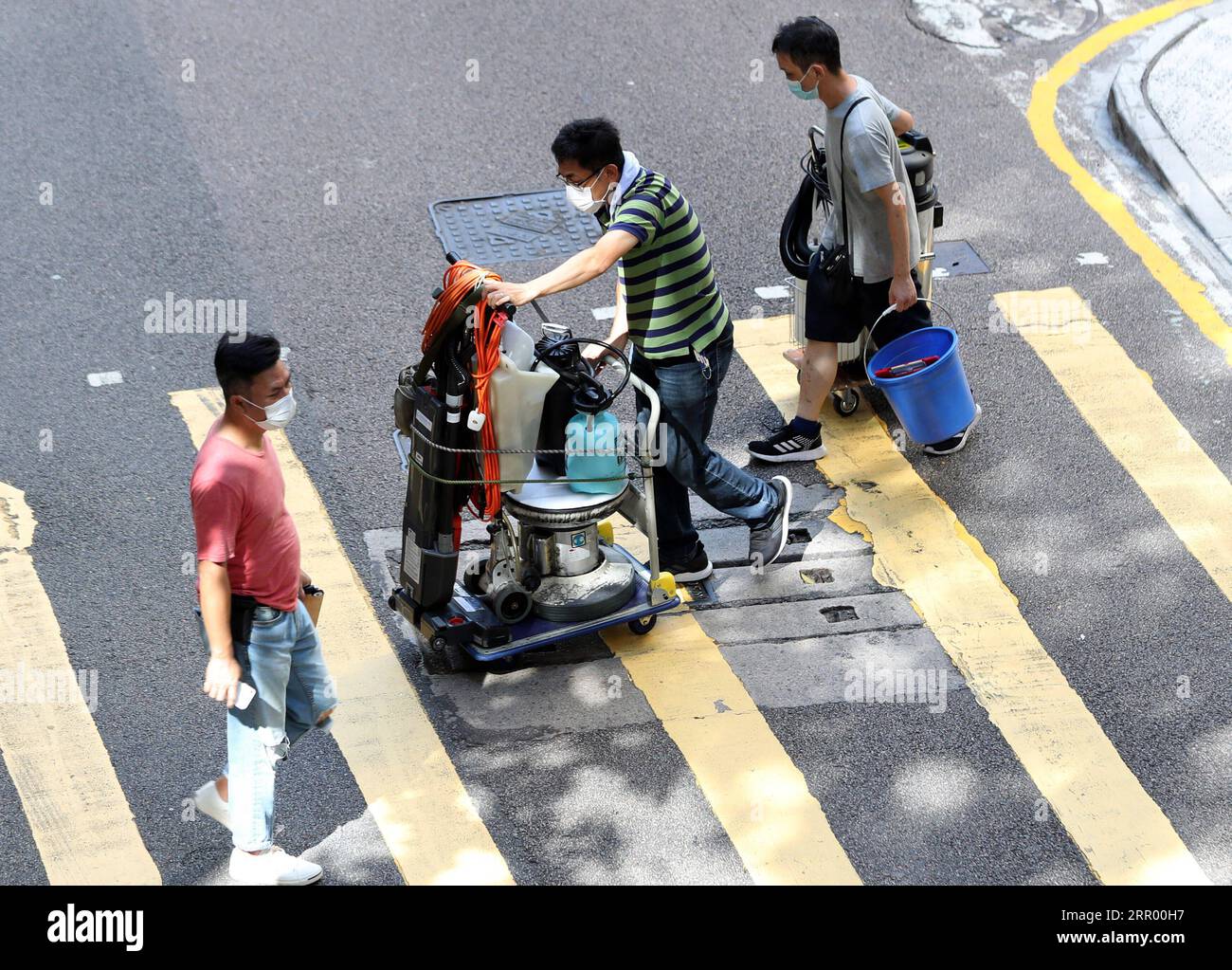 200721 -- HONG KONG, le 21 juillet 2020 -- des travailleurs traversent une rue avec de l'équipement à Hong Kong, dans le sud de la Chine, le 13 juillet 2020. Le taux de chômage de Hong Kong est resté le plus élevé en plus de 15 ans au cours des trois derniers mois, alors que l’économie était toujours aux prises avec les doubles coups de l’épidémie de COVID-19 en cours et des mois de troubles sociaux l’année dernière. POUR ALLER AVEC le taux de chômage de Hong Kong reste à plus de 15 ans TAUX DE CHÔMAGE élevé CHINE-HONG KONG CN LixGang PUBLICATIONxNOTxINxCHN Banque D'Images
