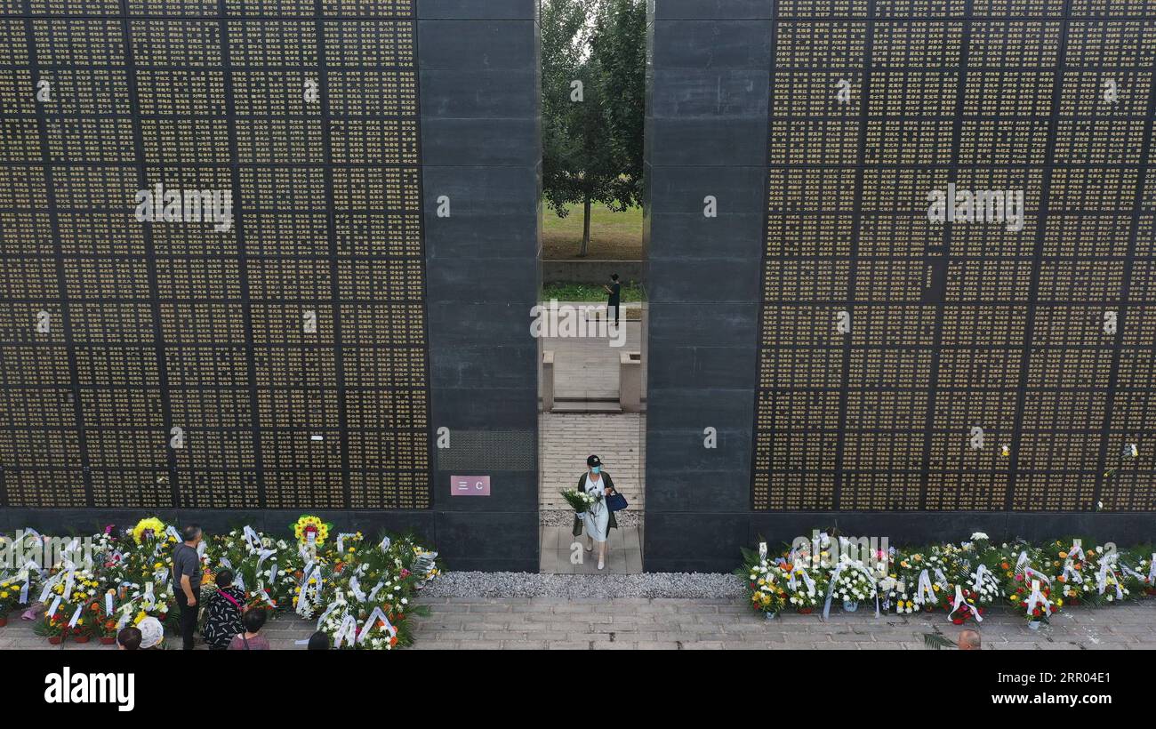 200728 -- TANGSHAN, le 28 juillet 2020 -- Une femme tenant des fleurs passe devant les murs commémoratifs de Tangshan, dans la province du Hebei du nord de la Chine, le 28 juillet 2020, 44e anniversaire du tremblement de terre de Tangshan en 1976. Photo de /Xinhua CHINA-HEBEI-TANGSHAN-EARTHQUAKE-ANNIVERSARY CN DongxJun PUBLICATIONxNOTxINxCHN Banque D'Images